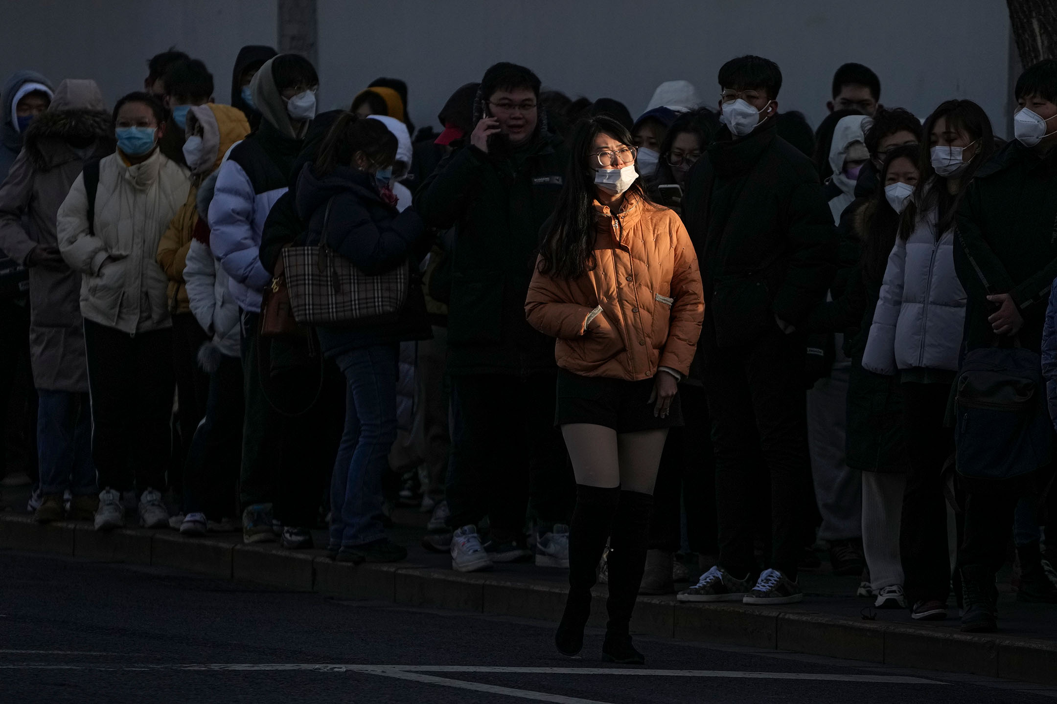 2023年2月13日，中国北京，一名女子在街道上经过。摄：Andy Wong/AP/达志影像