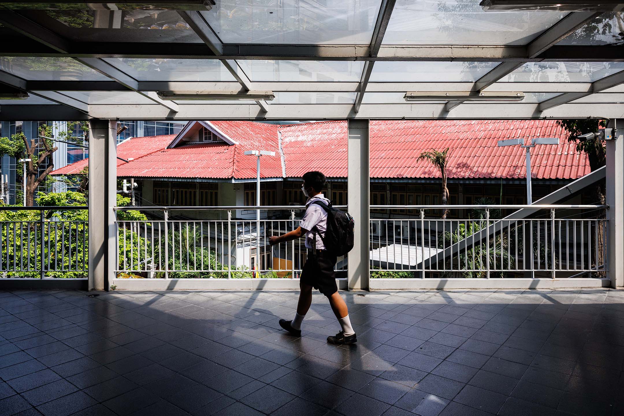 2023年5月18日，泰国曼谷，一名学生在天桥上走路。摄：Andre Malerba/Bloomberg via Getty Images