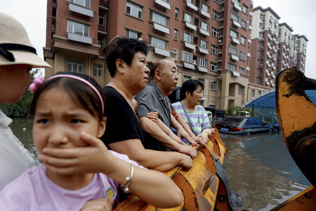 2023年8月3日，中国河北涿州，台风带来的降雨和洪水过后，人们站在被淹没的住宅区疏散。摄：Tingshu Wang/Reuters/达志影像