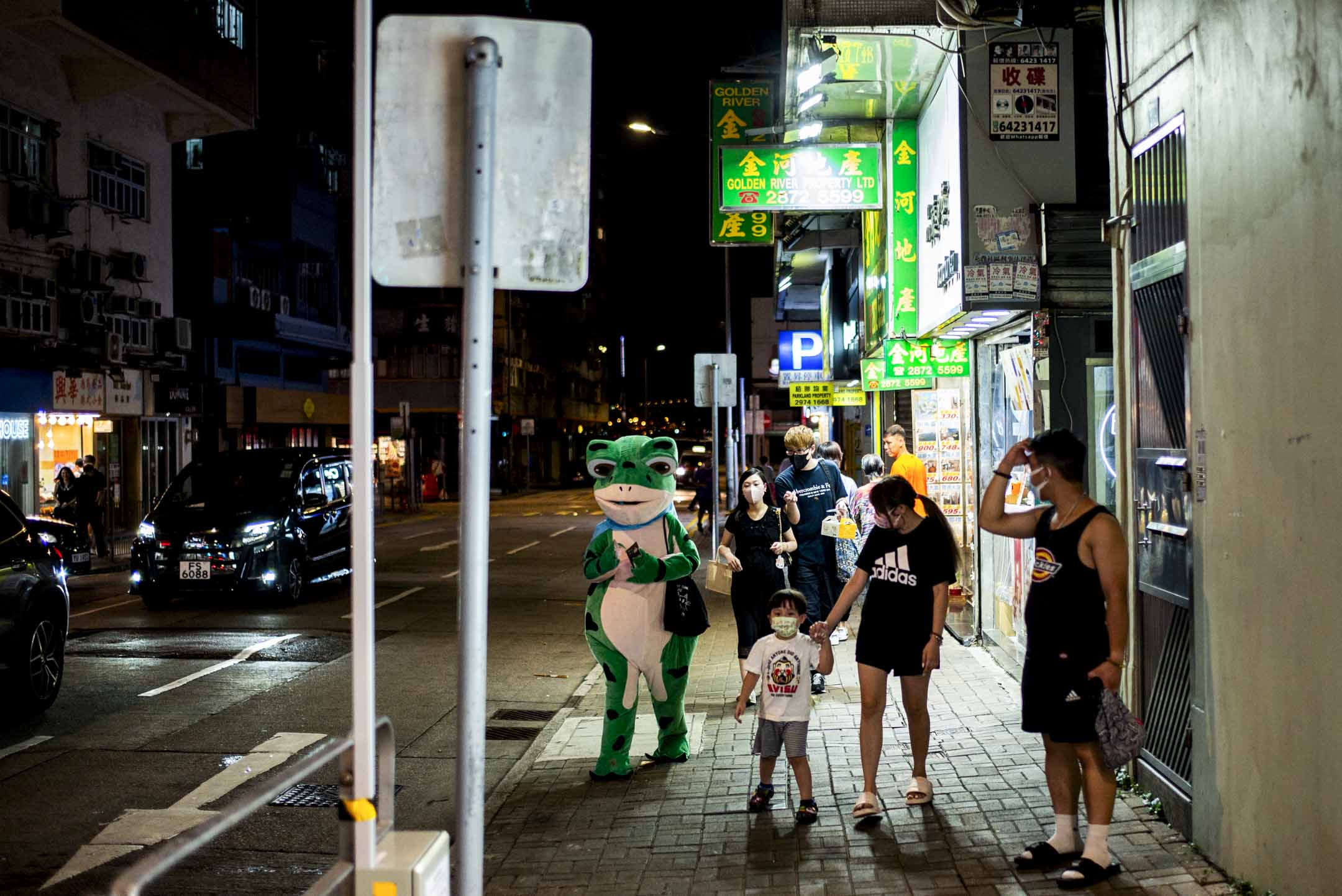 2023年9月21日，晚上，坚尼地城的街上有一只打扮成青蛙公仔的人。摄：林振东/端传媒 