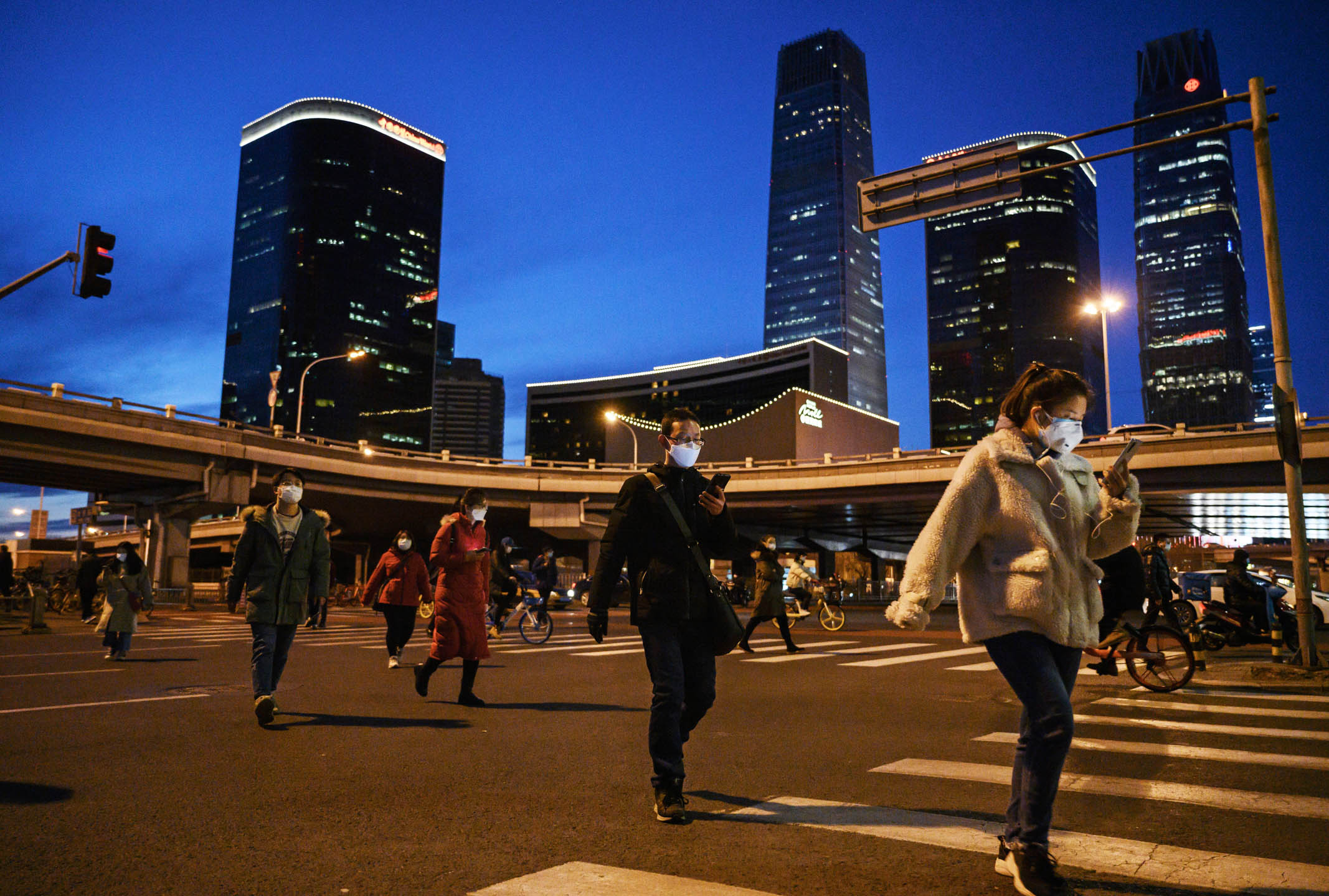  2020年3月12日，中国北京，在中央商务区下班的人群过马路。摄：Kevin Frayer/Getty Images