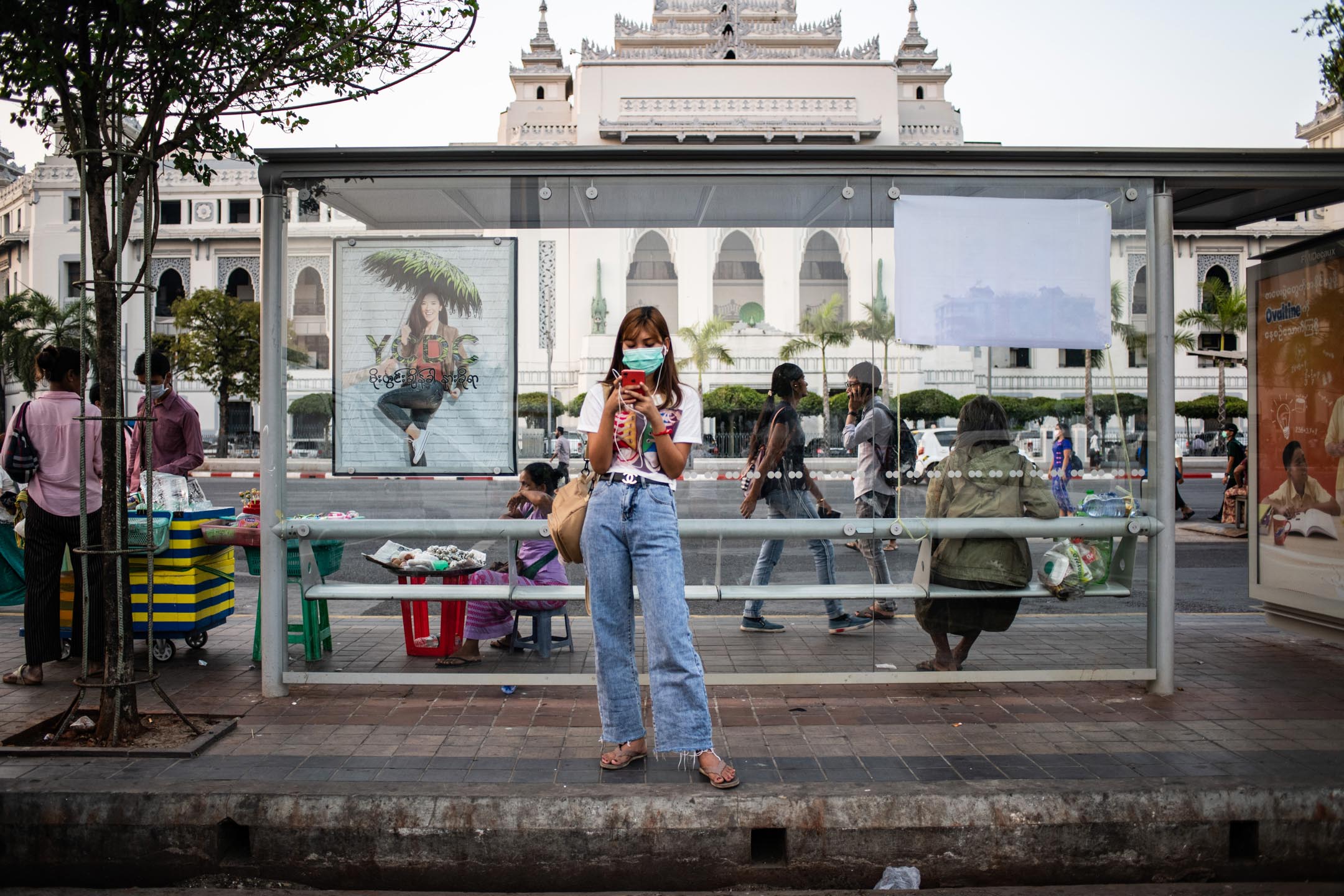 2020年3月24日，缅甸，一名女士在街道上看手机。摄：Shwe Paw Mya Tin/NurPhoto via Getty Images