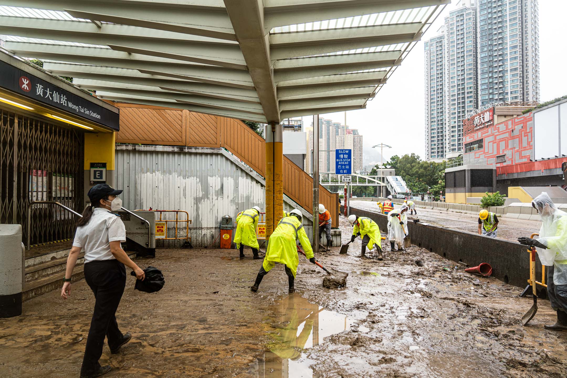 2023年9月8日，大暴雨過後，黃大仙地鐵站出口外工人正在清理污泥。攝：Ryan Lai/端傳媒