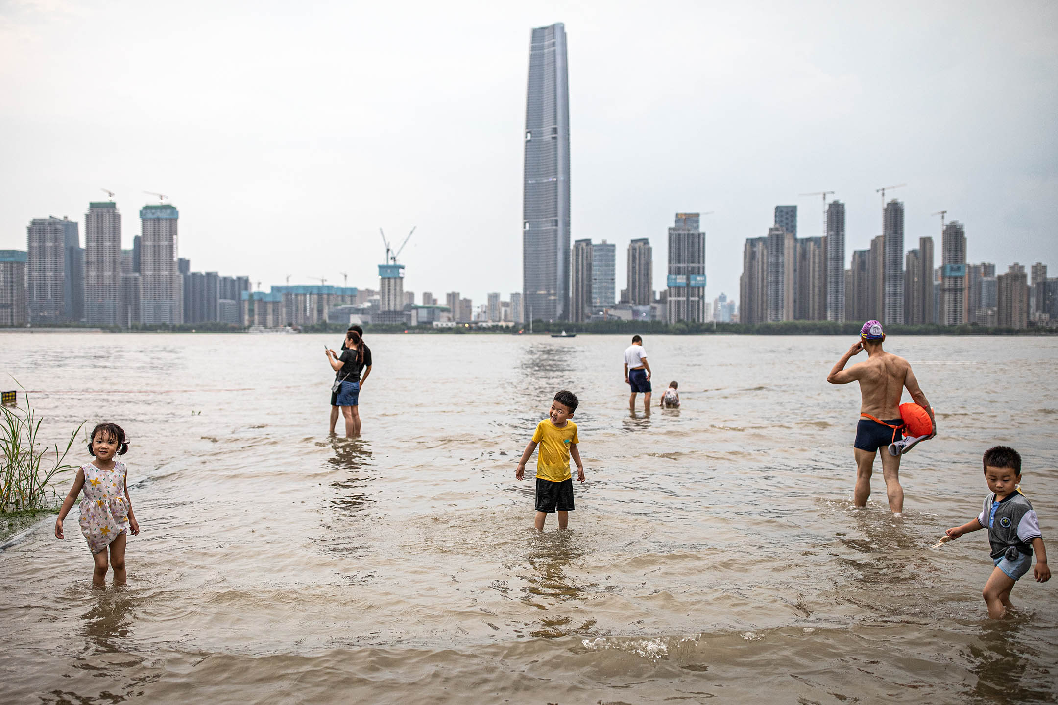 2022年6月10日，中国武汉，孩子在被洪水淹没的江滩公园内玩耍。摄：Getty Images