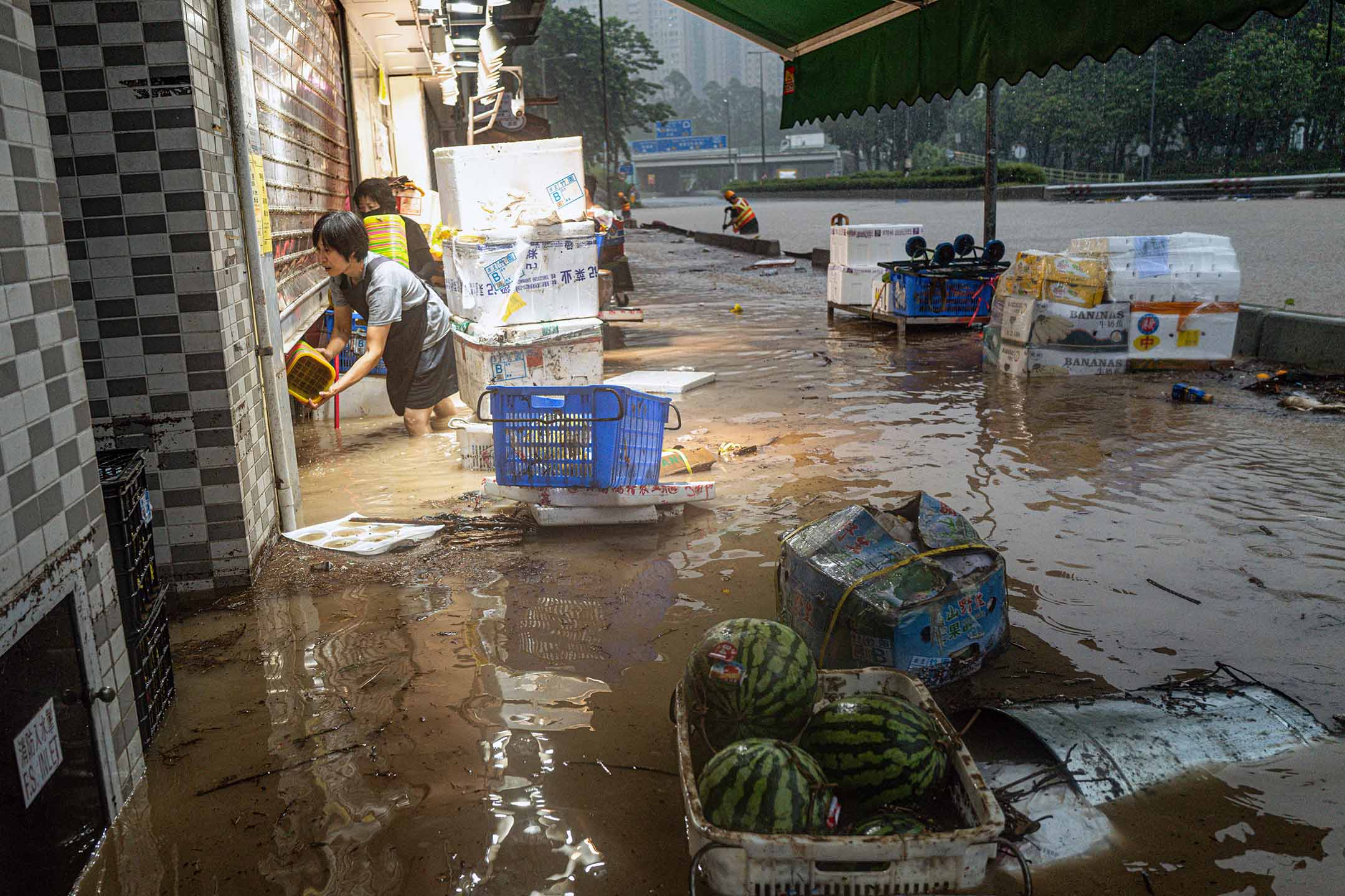 2023年9月8日，香港，暴雨期間，店主在處理被水淹沒的商店。攝：Lam Yik/Bloomberg via Getty Images