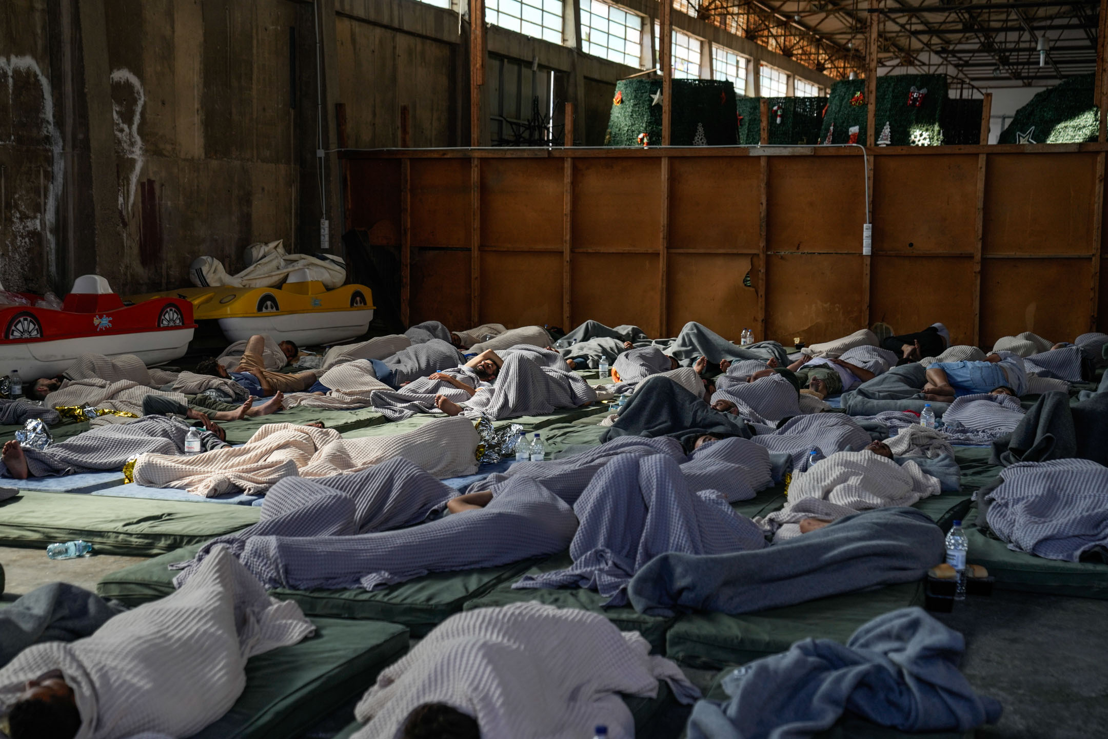 2023年6月14日，希腊，沉没船只的幸存者，在仓库内休息。摄：Thanassis Stavrakis/AP/达志影像