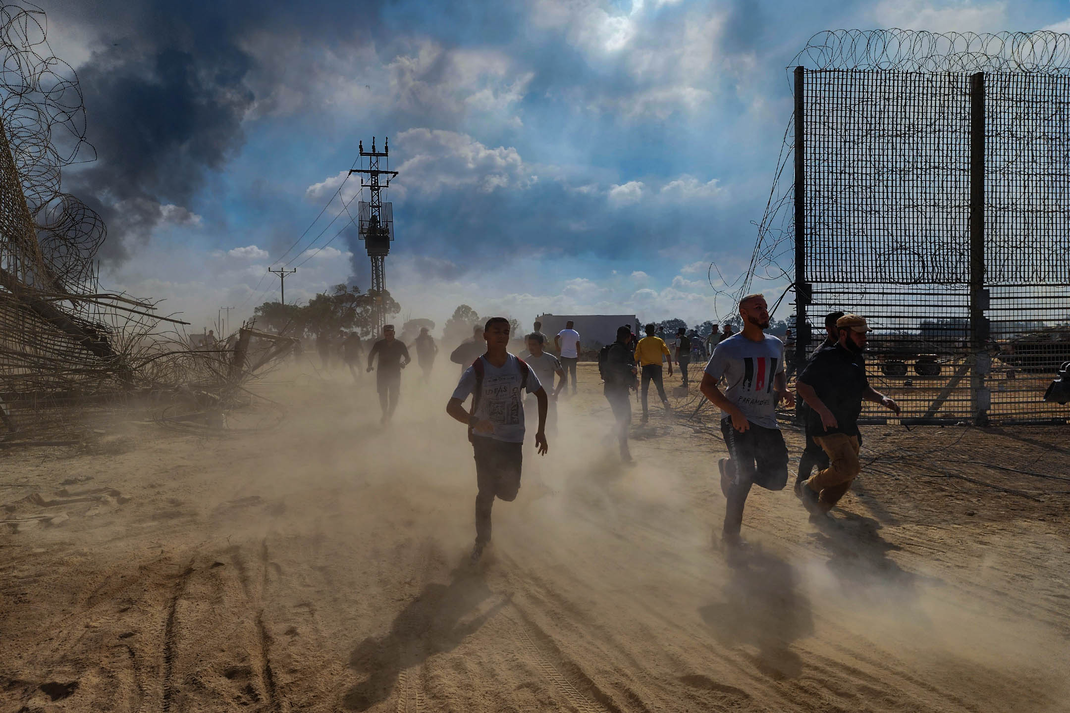 2023年10月7日，巴勒斯坦人拆除以色列与加萨边境的围栏。摄：Hani Alshaer/Anadolu Agency via Getty Images