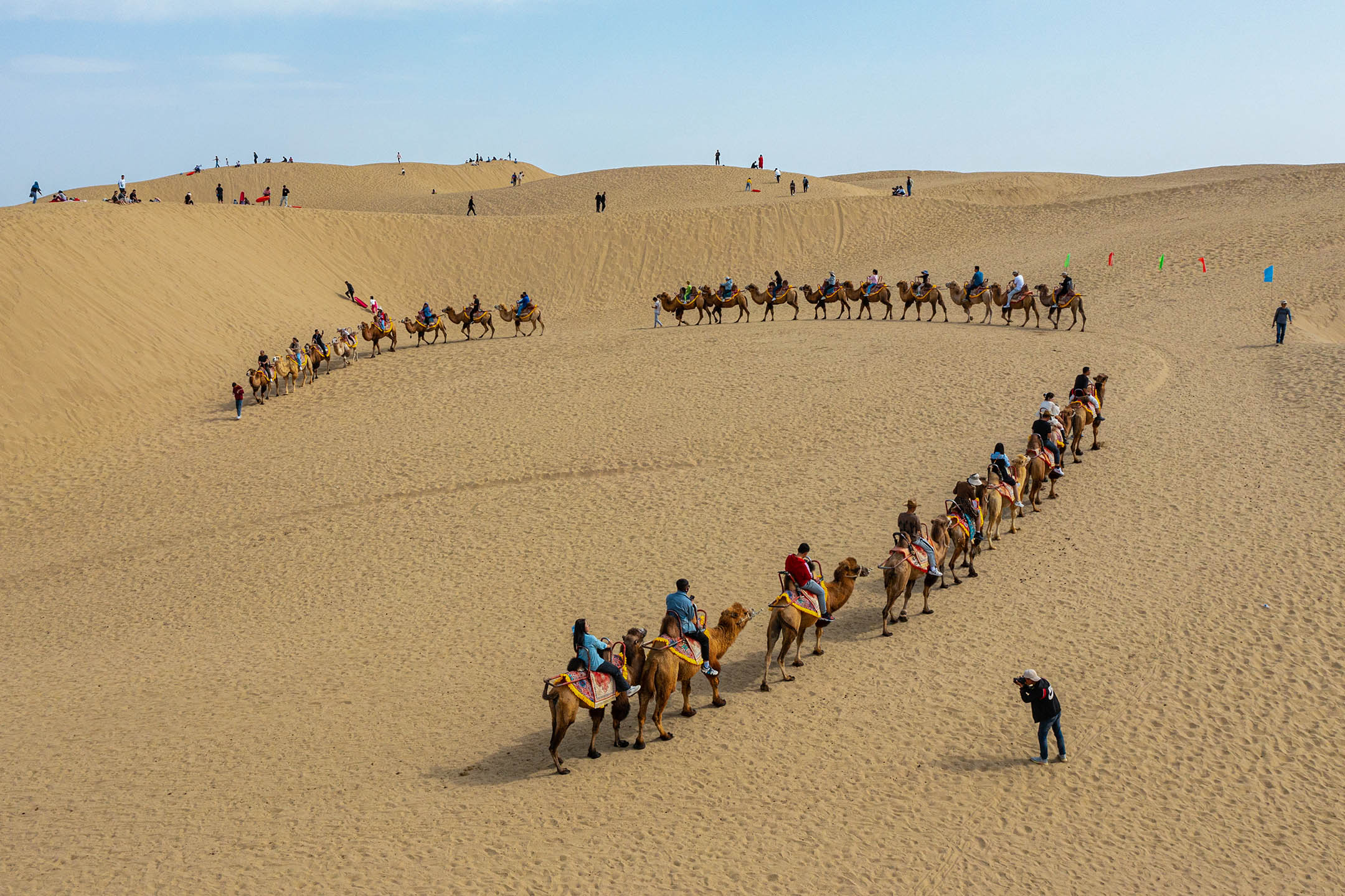 2023年10月5日，游客在新疆巴音郭楞蒙古自治州骑骆驼。摄：Costfoto/NurPhoto via Getty Images