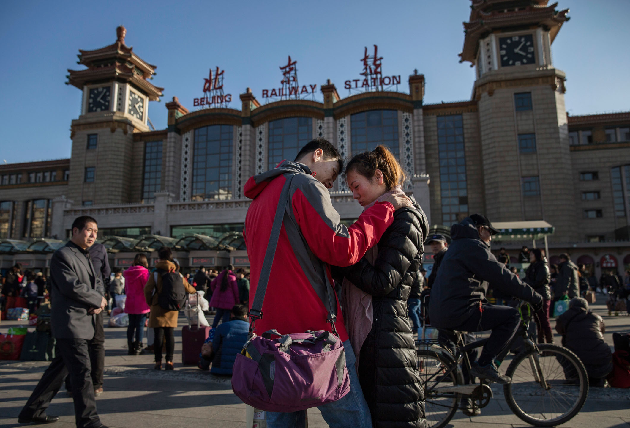 2015年2月17日，中國北京，春節假期前，市民在當地火車站外告別。攝：Kevin Frayer/Getty Images