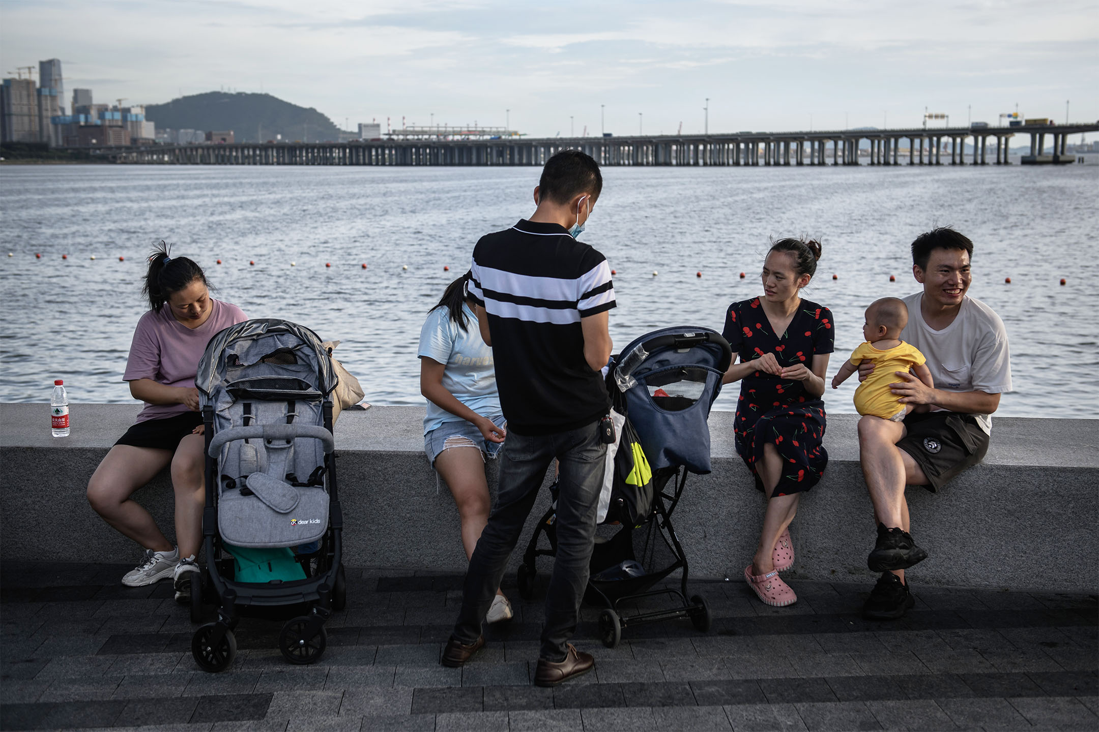 2022年6月6日，中国深圳，父母手推婴儿车到海旁散步。摄：Stringer/Anadolu Agency via Getty Images