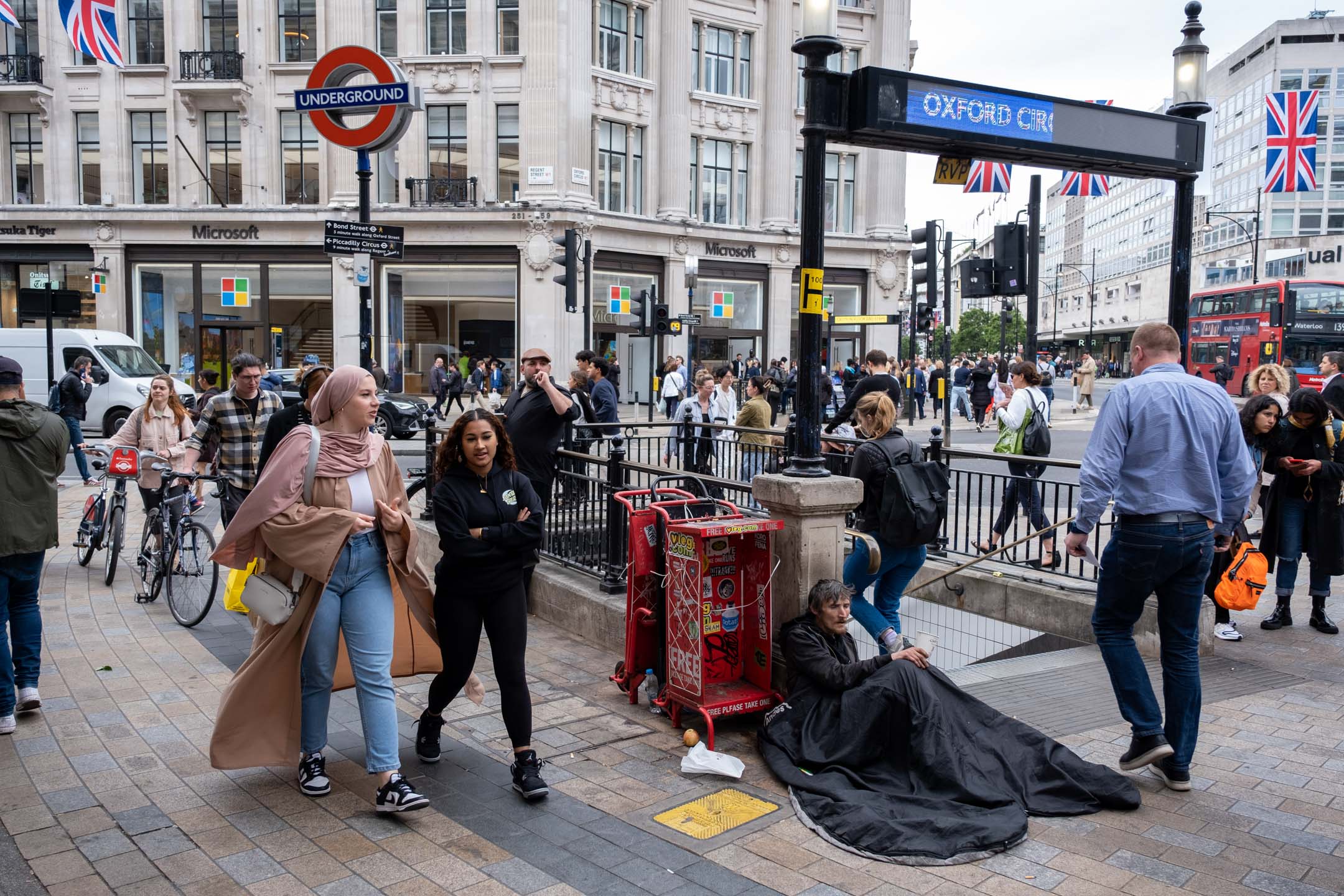 2023年5月22日，英国伦敦，市民和游客在一名无家者身旁经过。摄：Mike Kemp/In Pictures via Getty Images