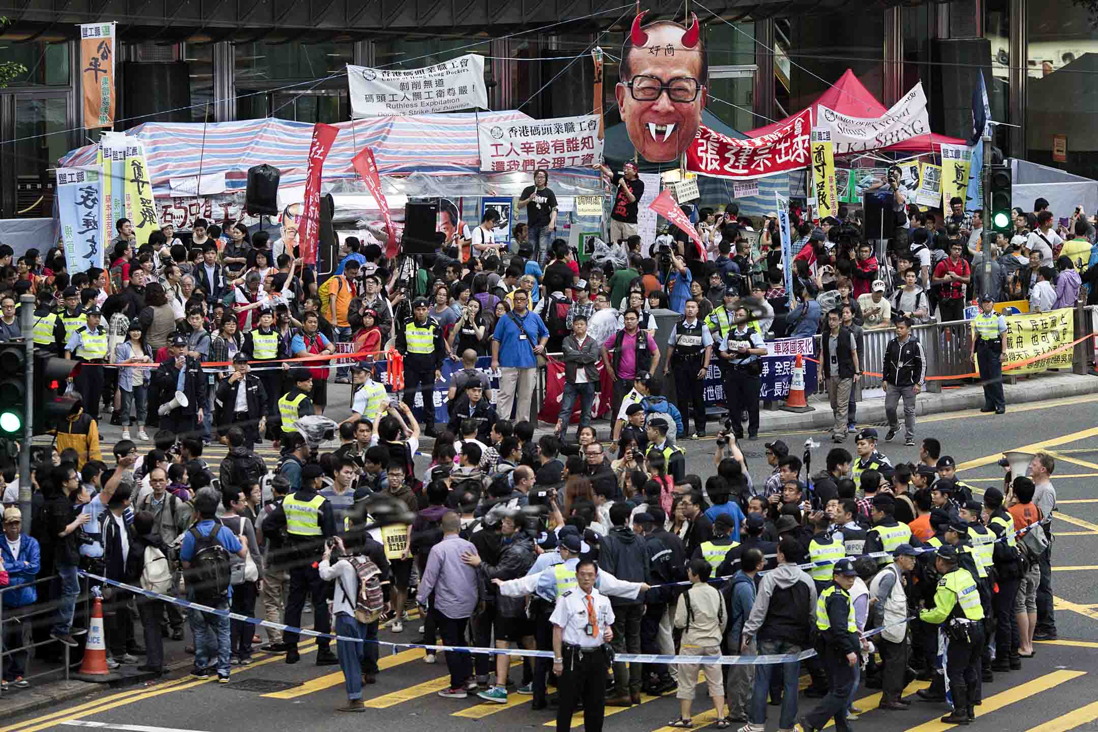 2013年5月1日，香港码头工人在劳动节游行期间聚集在长江中心外。摄：Jerome Favre/Bloomberg via Getty Images