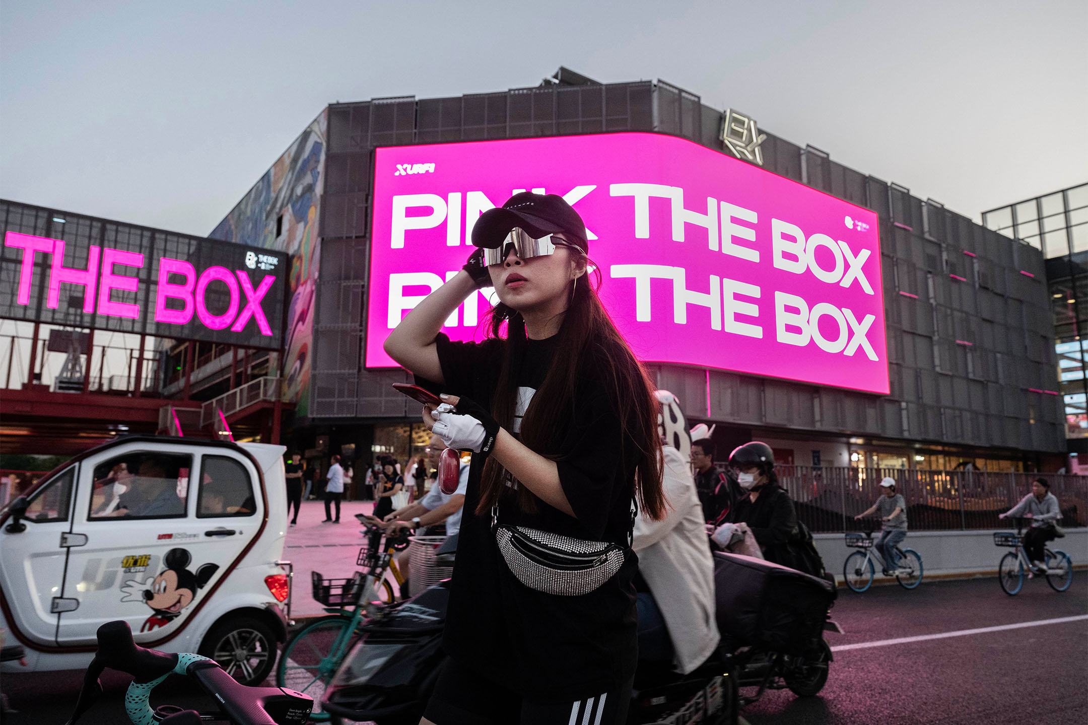 2023年9月13日，中国北京，一名女子骑著自行车等待过马路。摄：Kevin Frayer/Getty Images