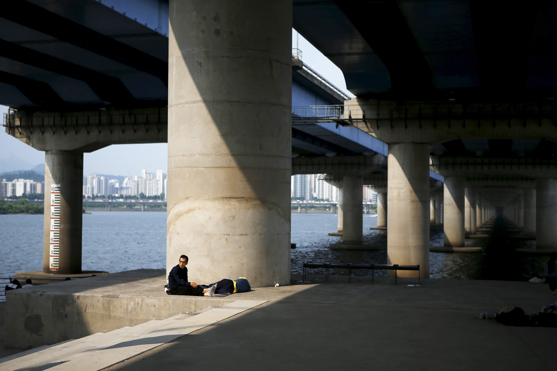 2015年6月22日，韩国首尔汉江公园，一名男人在桥下休息。摄：Kim Hong-Ji/Reuters/达志影像