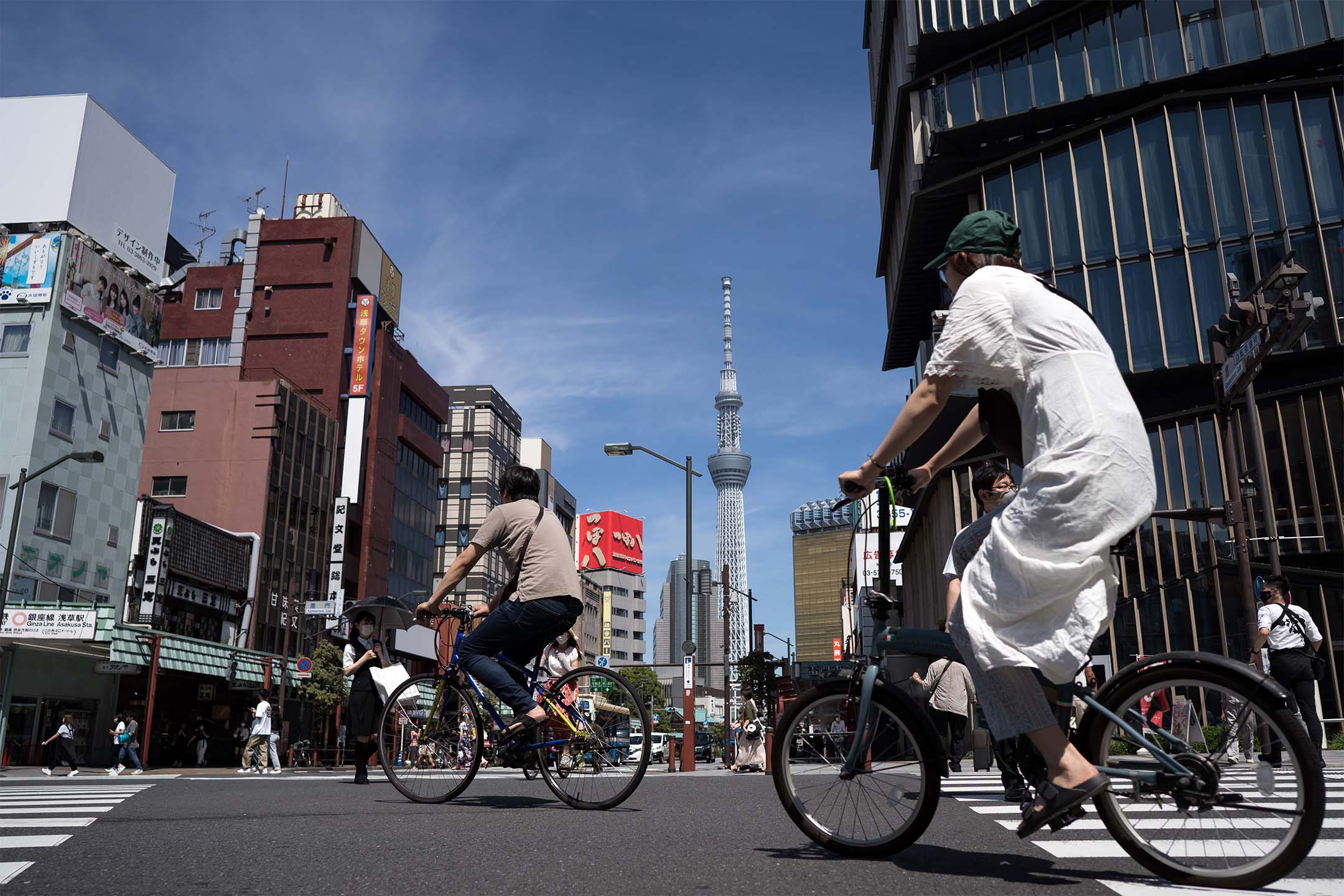 2022年6月29日，人们骑自行车经过浅草地区的东京晴空塔。摄：Tomohiro Ohsumi/Getty Images