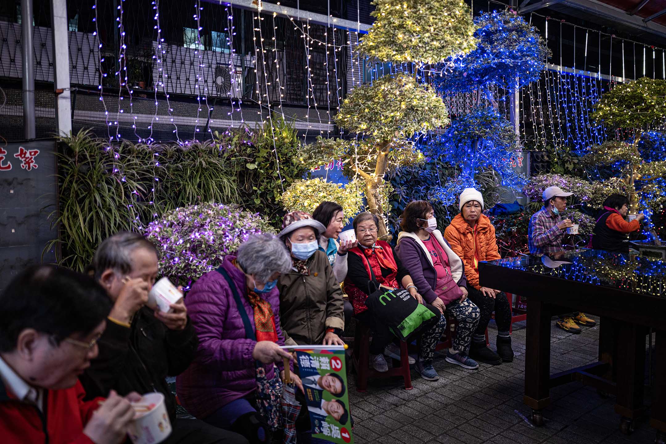 2023年12月26日，新北市，民进党立委候选人吴峥参香拜票，宫庙内的民众吃著米粉等食物。摄：陈焯煇/端传媒