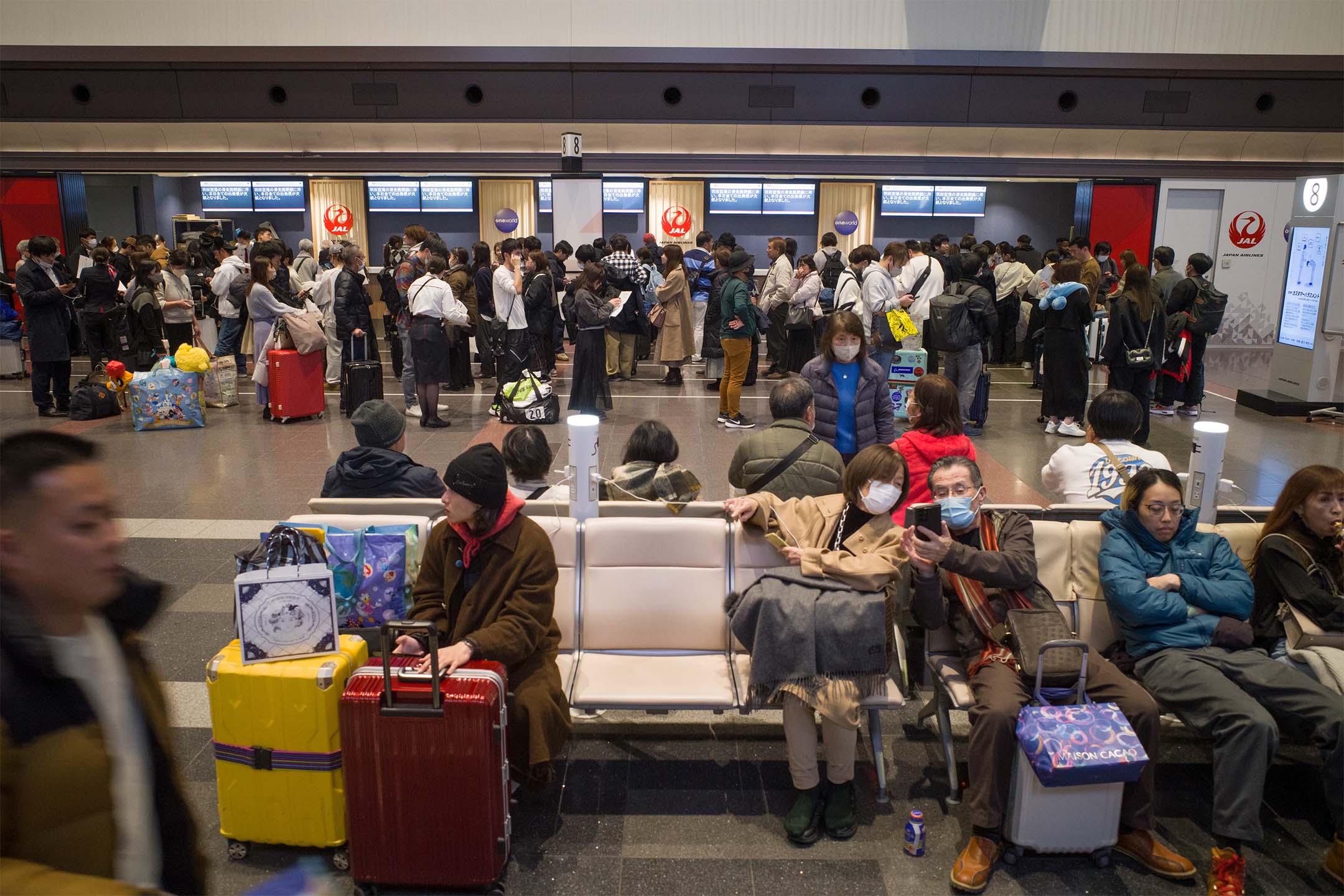 2024年1月2日，日本，因飞机相撞导致航班取消，大批旅客在羽田机场的日本航空公司服务柜台排队。摄：Kentaro Takahashi/Bloomberg via Getty Images