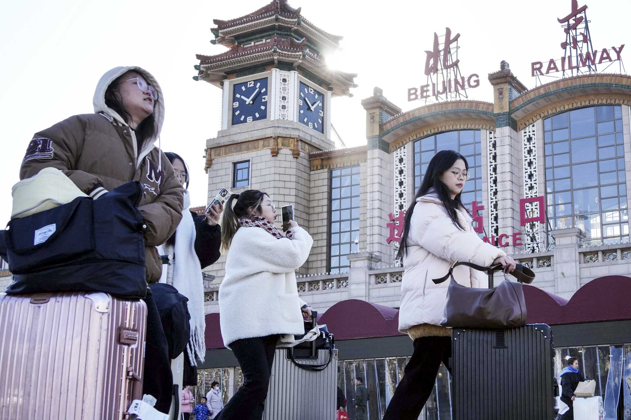 2024年1月26日，中国北京，旅客携带行李在春节前从北京站出发。摄：The Yomiuri Shimbun via AP/达志影像