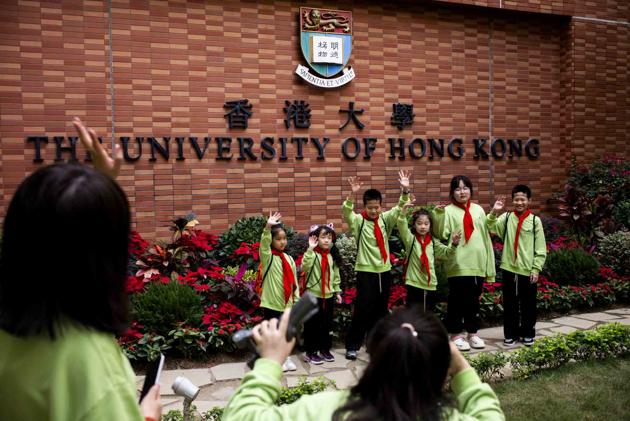 游客在港大的百周年校园，写着“香港大学”的纪念墙前排队轮候留影。摄：林振东/端传媒