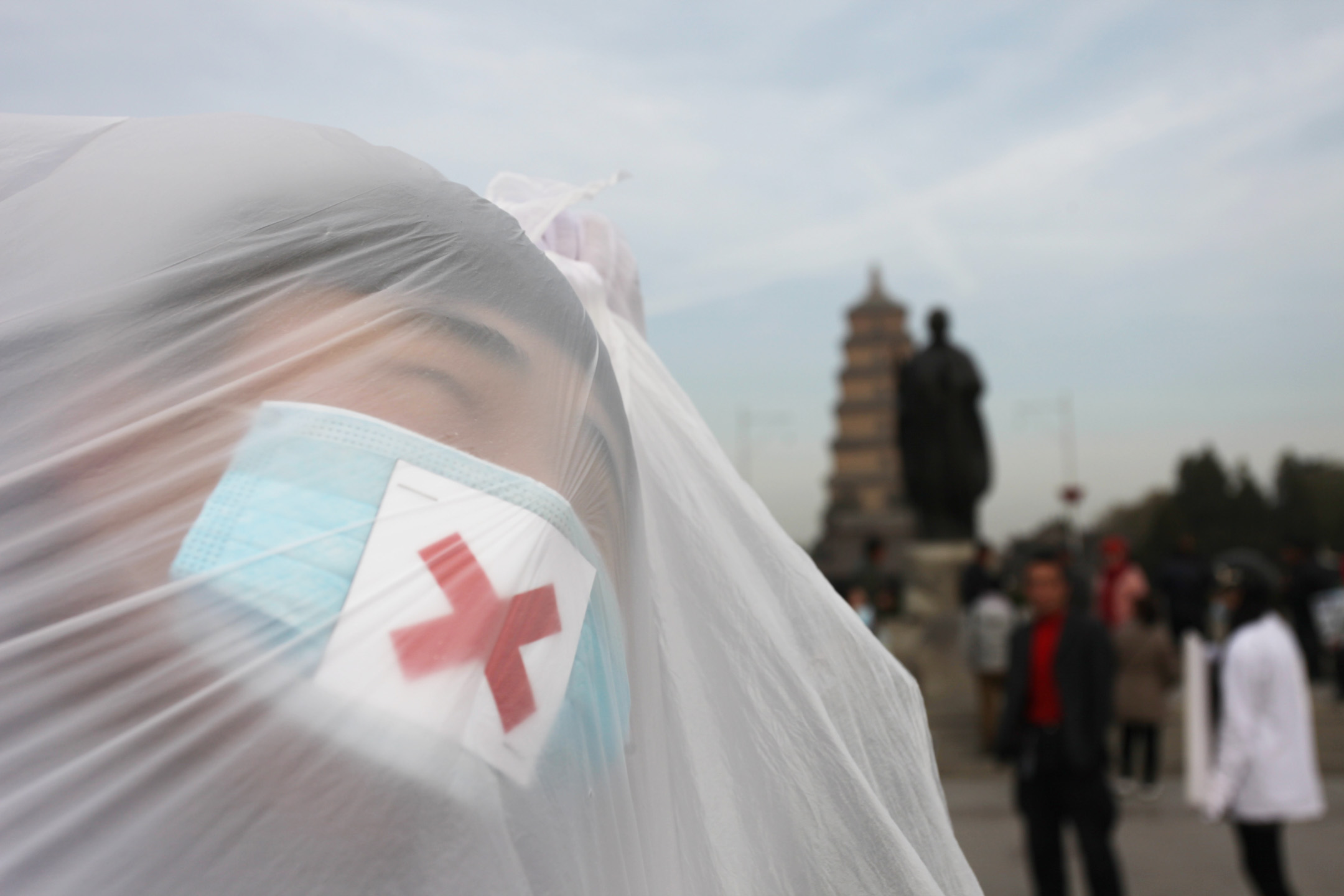 2013年12月5日，中国西安，大学生在街头上用用塑胶袋进行行为艺术。摄：Getty Images