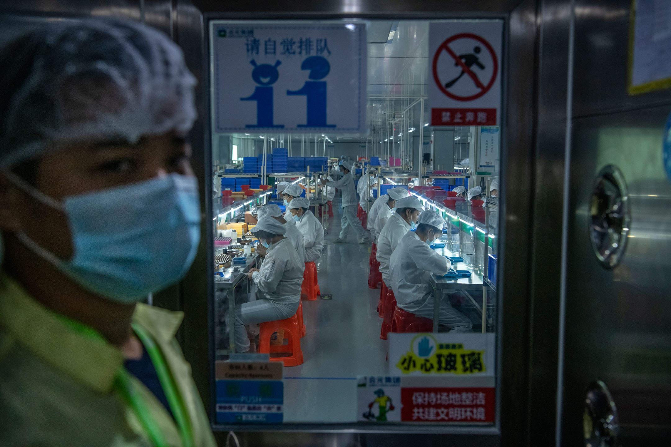 2019年9月25日，中国深圳，工人们在电子烟制作工厂工作。摄：Kevin Frayer/Getty Images