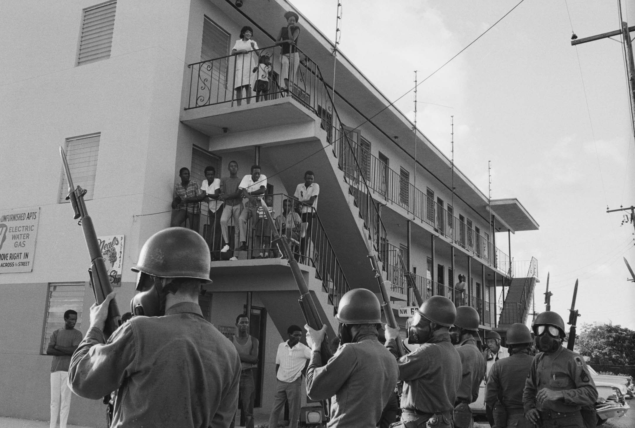 1968年，迈阿密自由城社区的居民和武装警察。摄：Getty Images