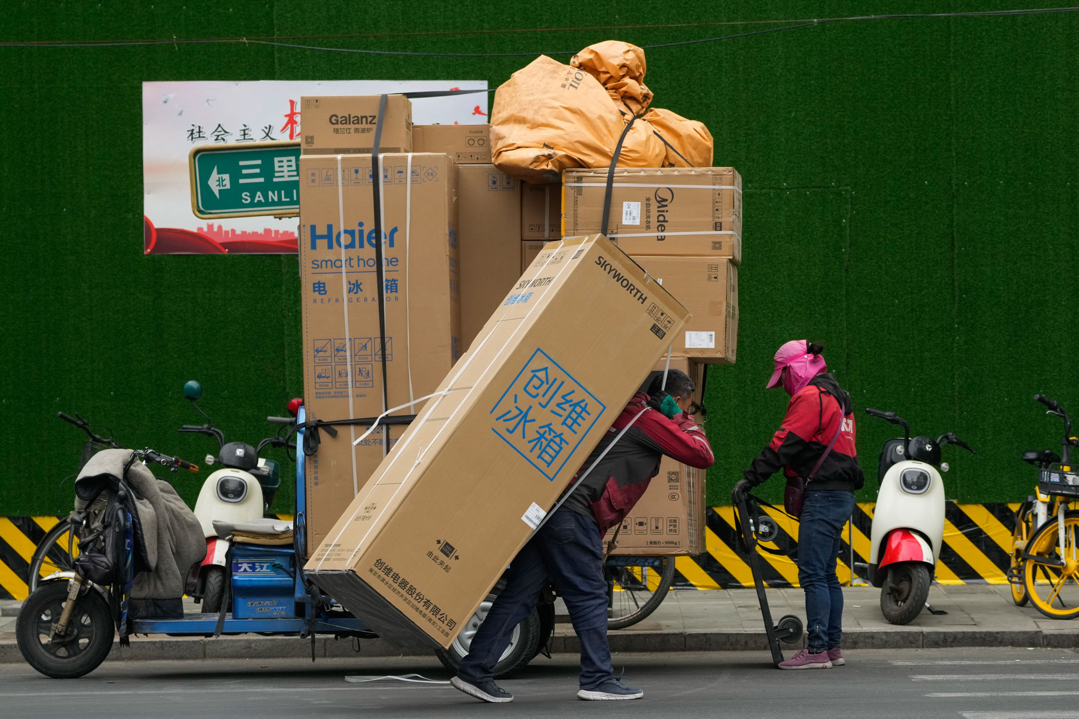 2023年4月27日，中国北京，一名送货员正在为顾客运送货品。摄：Andy Wong/AP/达志影像