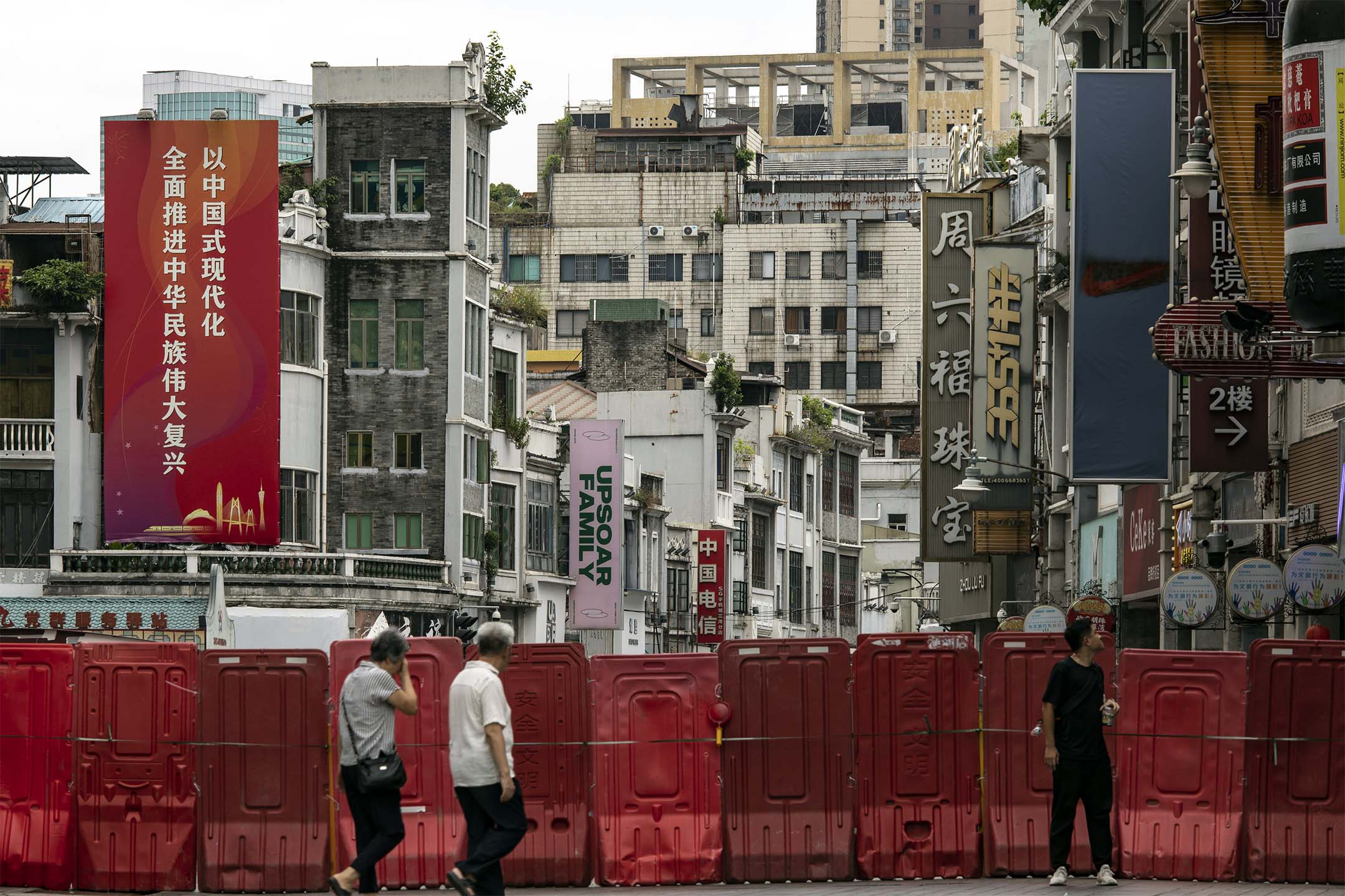 2023年8月11日，中国广州，市民在路障前经过。摄：Qilai Shen/Bloomberg via Getty Images