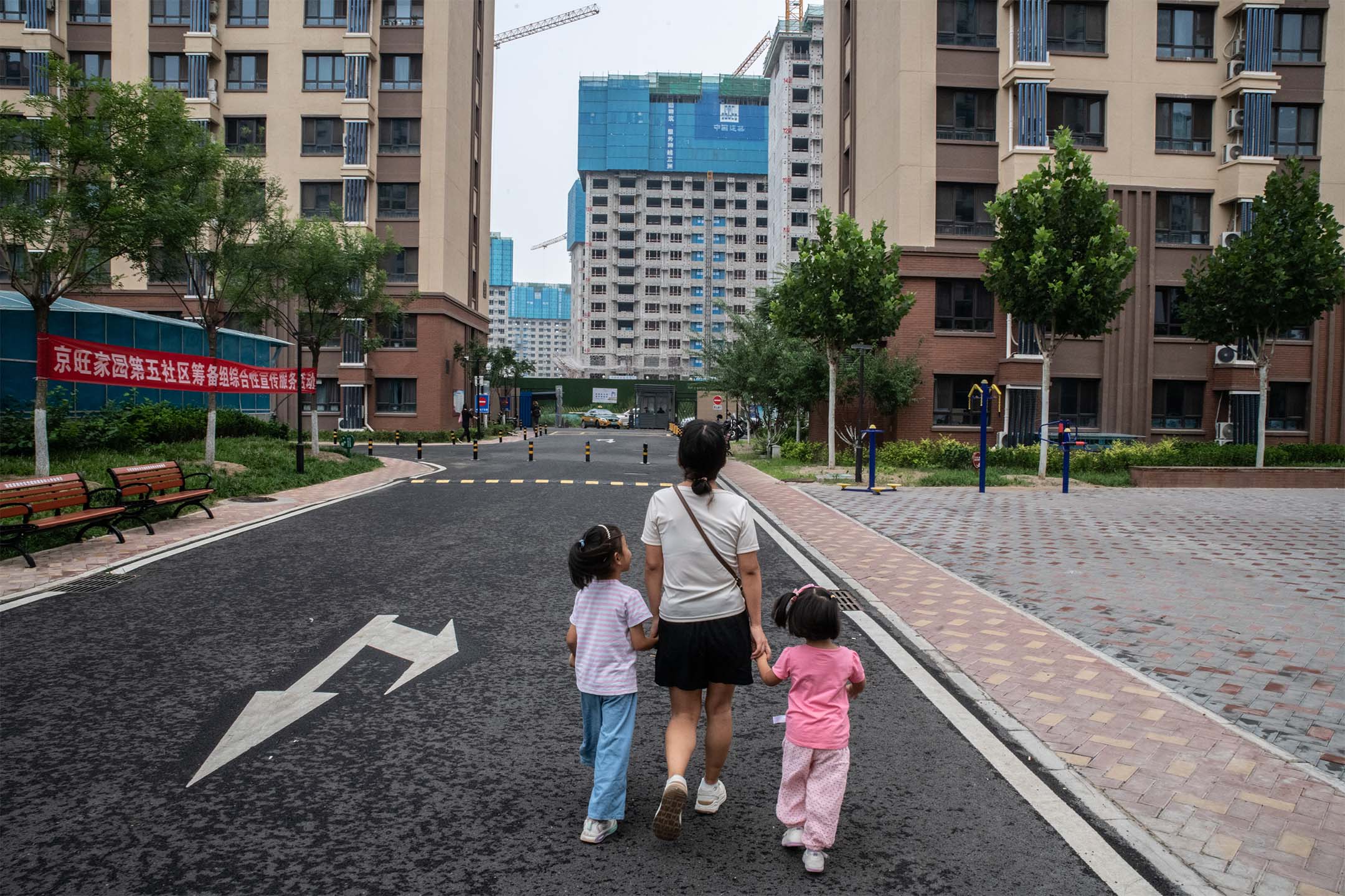 2023年8月11日，中国北京，人们正在看著兴建中的住宅大楼。摄：Bloomberg via Gettyimages