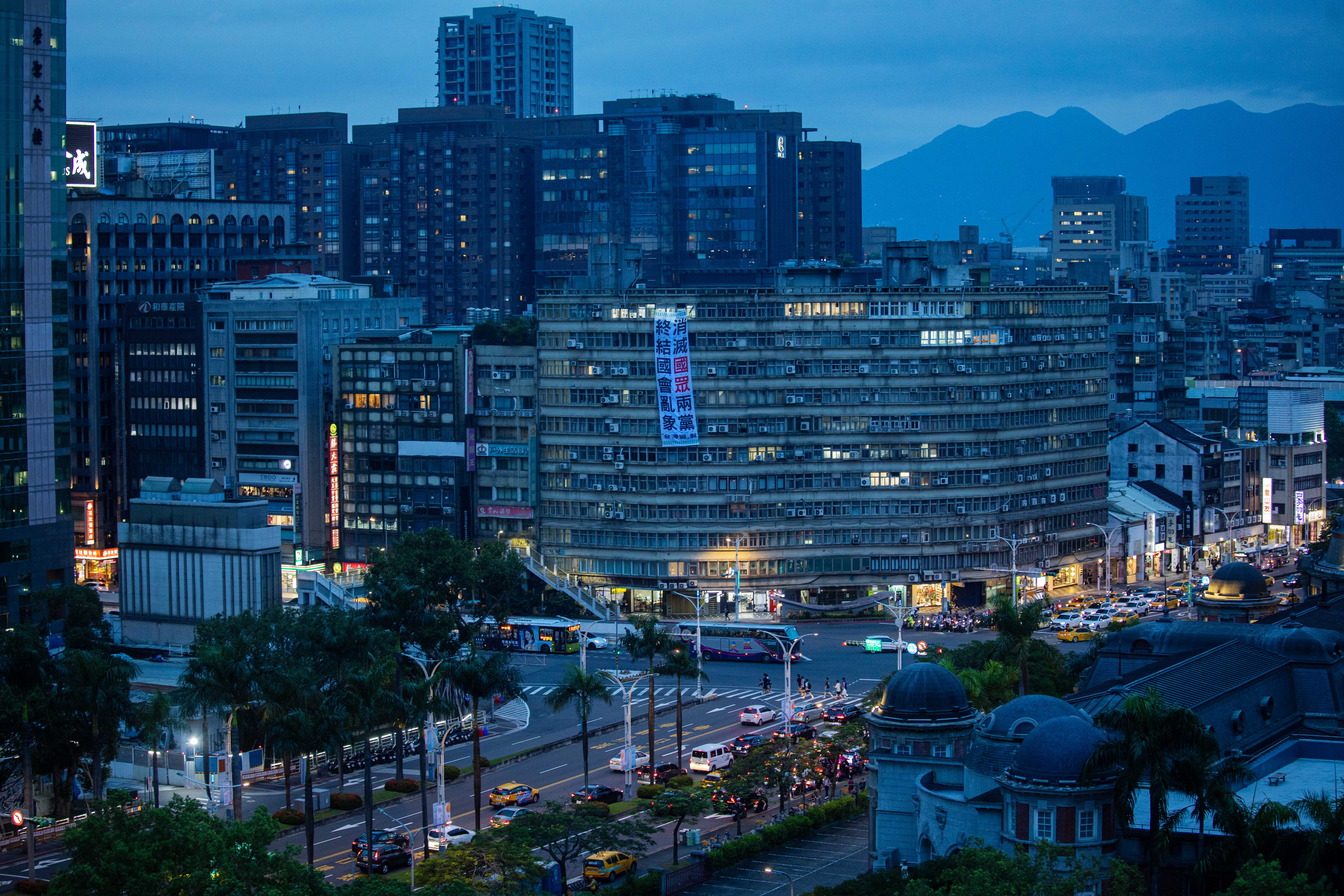 2024年6月20日，台北，立法院外一幢大厦外挂上反对国民党和民众党的布条。摄：陈焯煇/端传媒