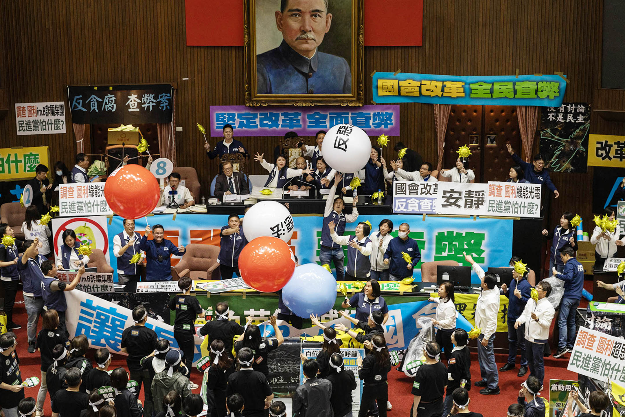 2024年5月28日，台北，立法院進行國會改革法案審議，立法院内民進黨向主席台抛汽球。攝：陳焯煇/端傳媒