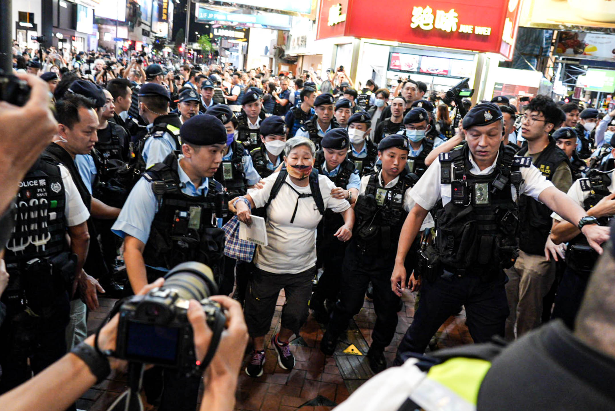 2024年6月4日，一名女士被警方包圍後帶上警車。攝：Ryan Lai/端傳媒