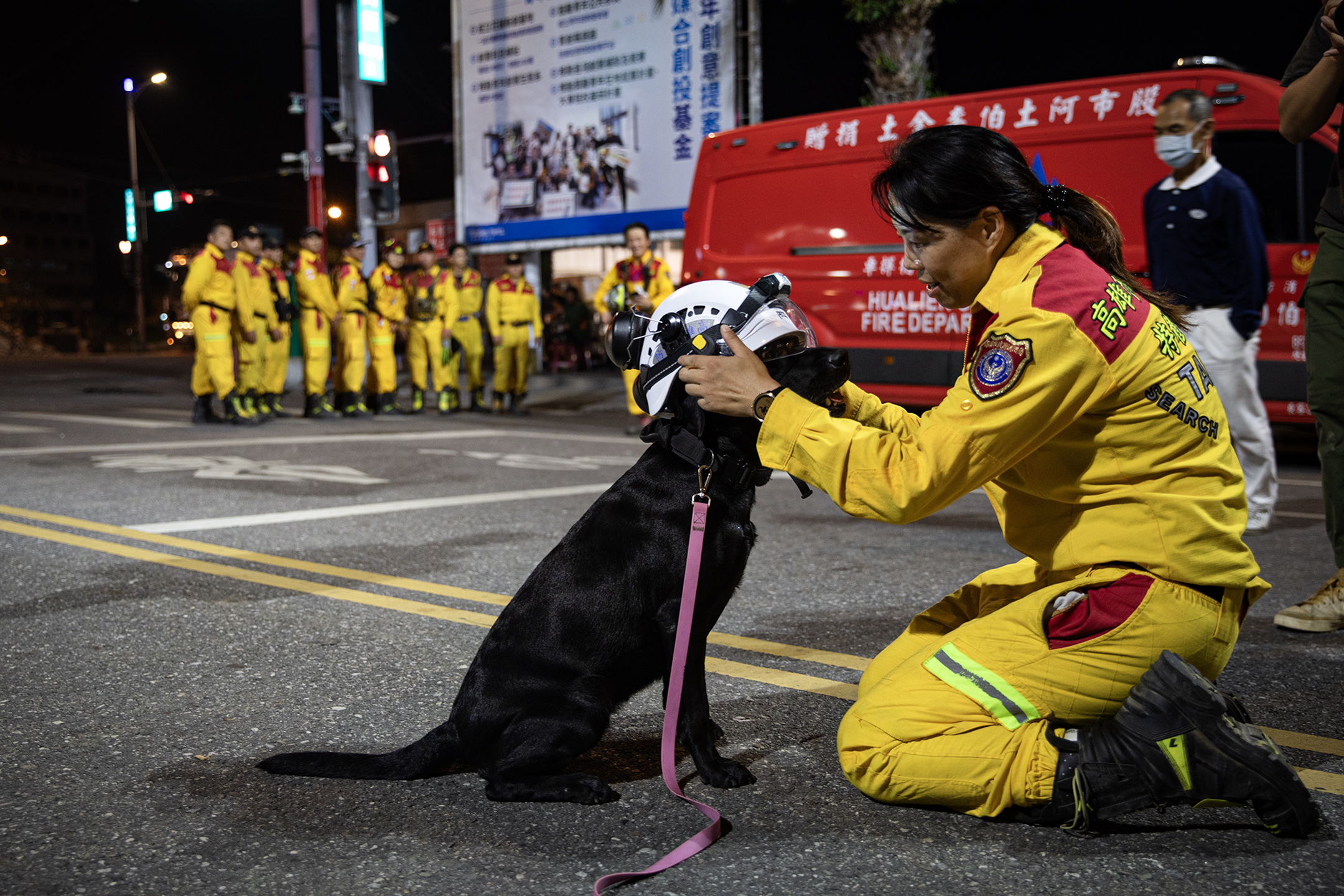 2024年4月3日，花莲，搜救人员在抚摸一只完成搜救工作的搜救犬。摄：陈焯煇/端传媒