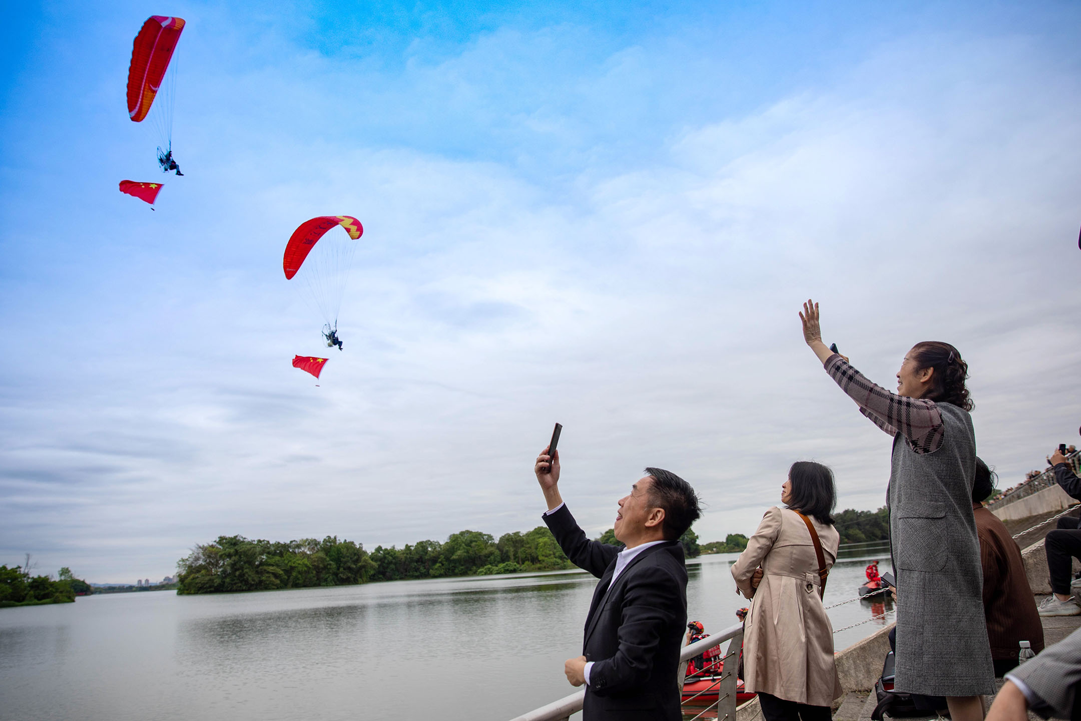 2024年4月30日，中國重慶舉行低空飛行消費周，人們在龍水湖附近觀賞低空飛行表演。攝：Huang Shu/VCG via Getty Images