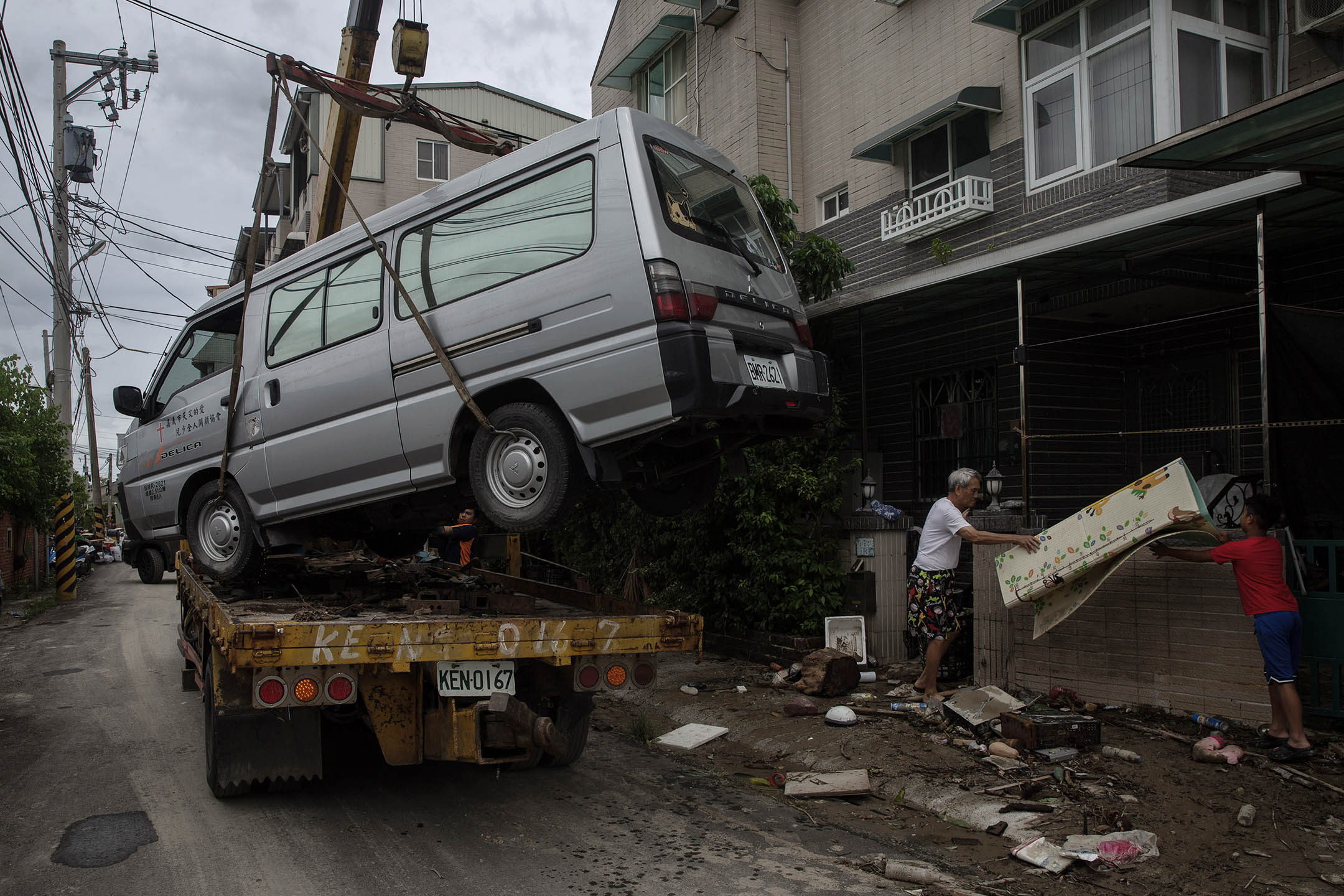 2024年7月27日，嘉義水上鄉，居民在移動一架在風災中毀壞的車。攝：陳焯煇/端傳媒