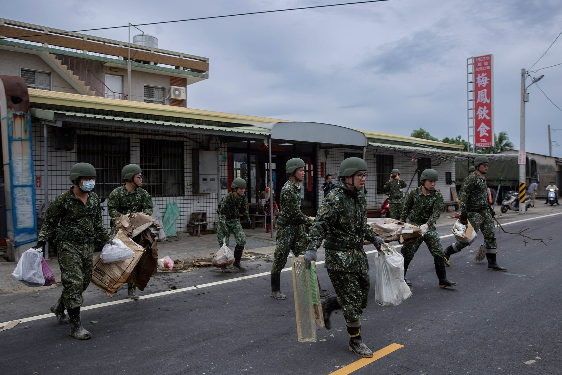 2024年7月27日，台南菁寮，軍人協助居民清理垃圾。攝：陳焯煇/端傳媒