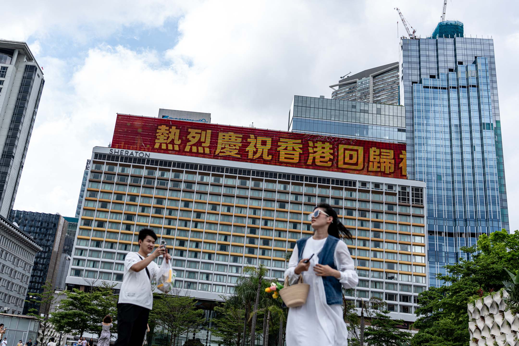 2024年7月1日，尖沙咀，有大厦显示屏上写有庆祝回归27周年的字句。摄：Ryan Lai/端传媒