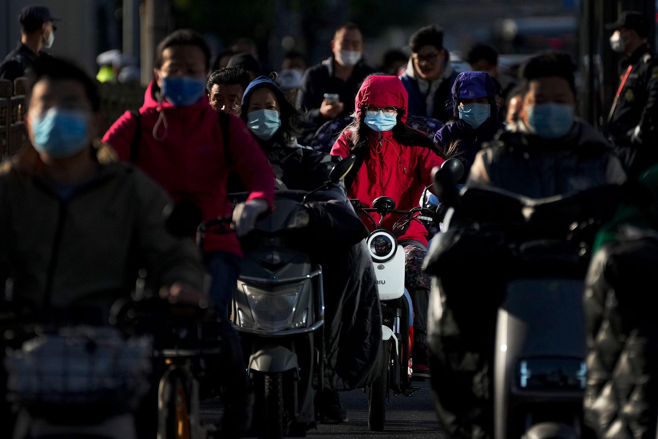 2022年10月16日，中國北京，人們在街上騎着電動車。攝：Andy Wong/AP/達志影像