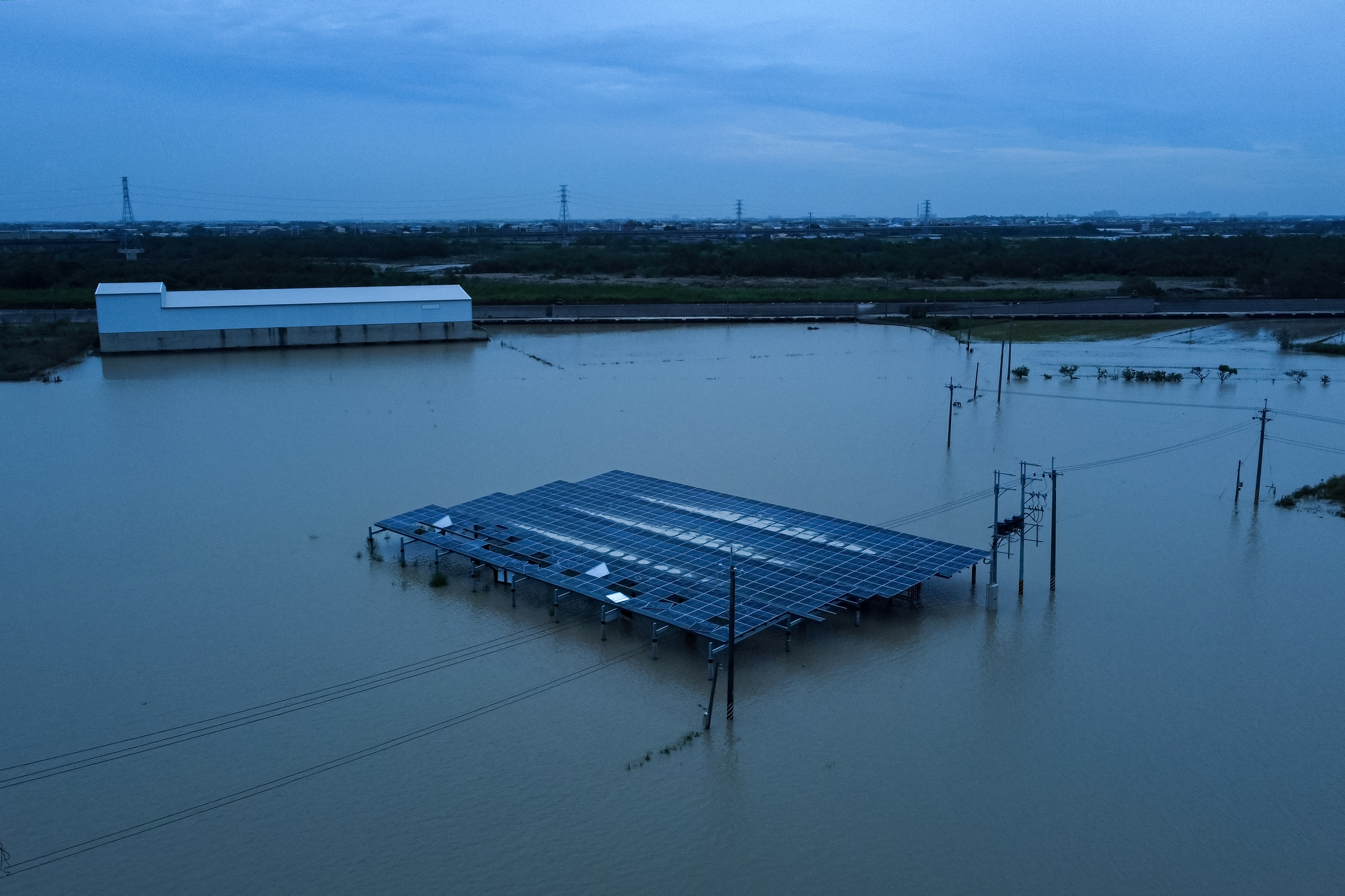 2024年7月27日，台南后璧，一片淹没了的农田及一组太阳能发电板。 摄：陈焯煇/端传媒