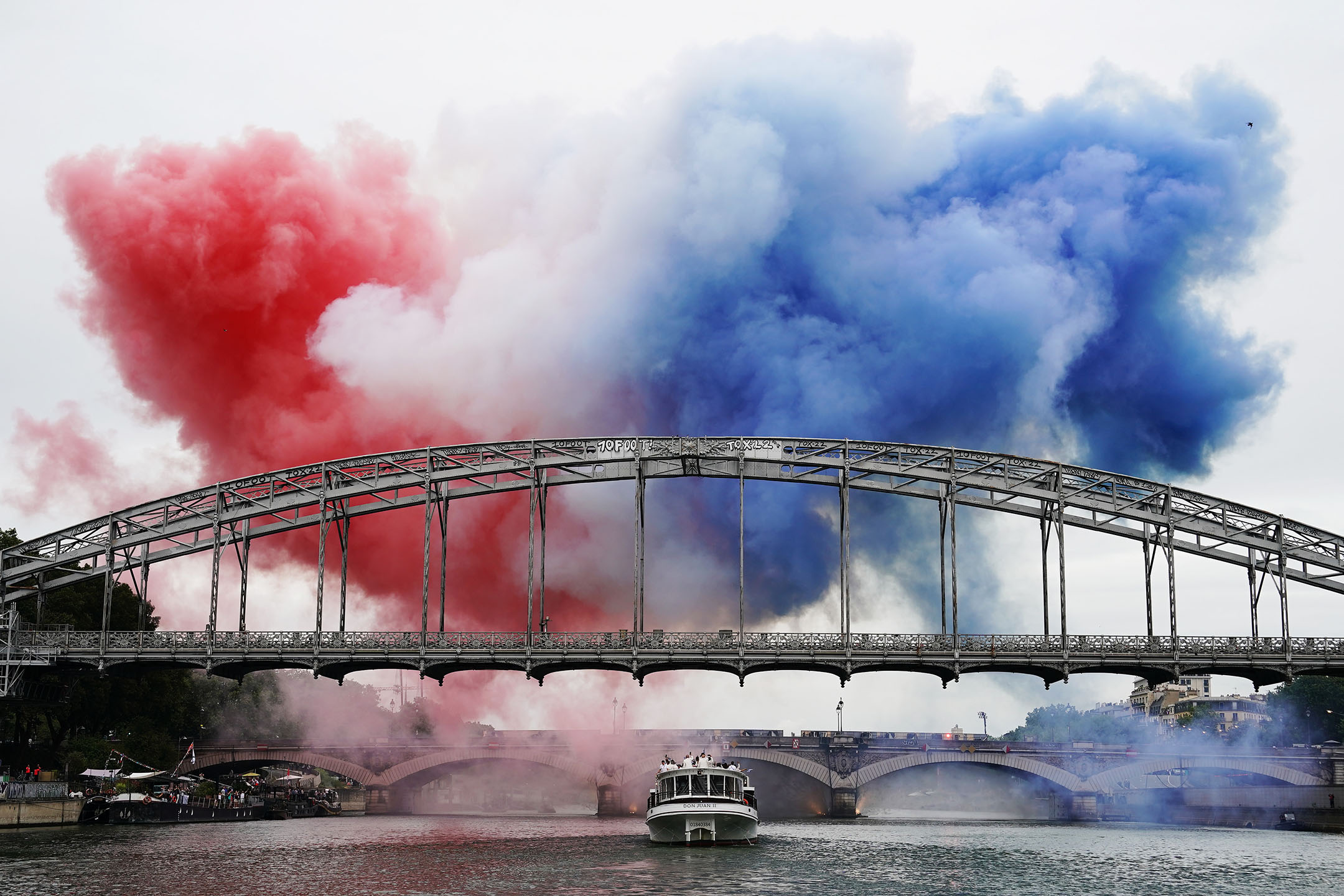 2024年7月26日，法國巴黎，橋上冒出法國國旗顏色的煙霧。攝：David Burnett/IOC via Getty Images