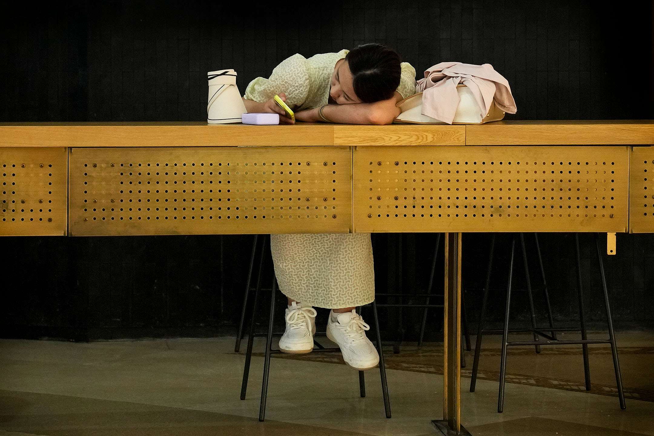 2023年6月21日，中國北京，一家咖啡店內女士在看手機。攝：Andy Wong/AP/達志影像