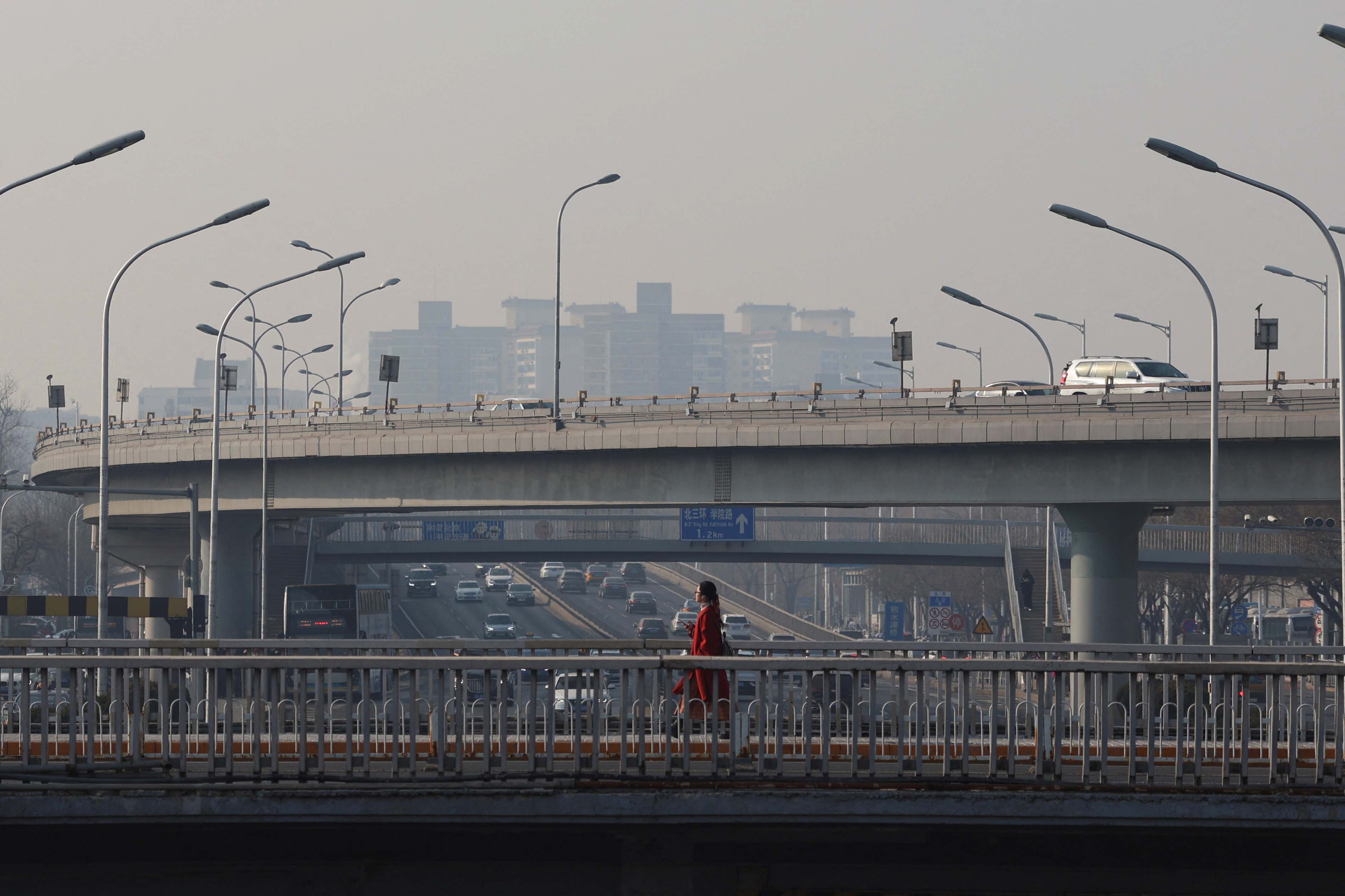 2024年1月12日，北京，一名行人在天桥上行走。摄：Florence Lo/Reuters/达志影像