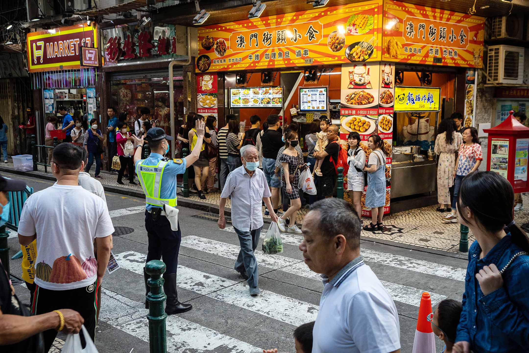 2023年4月30日， 澳門，行人在街道上過馬路。攝：Eduardo Leal/Bloomberg via Getty Images