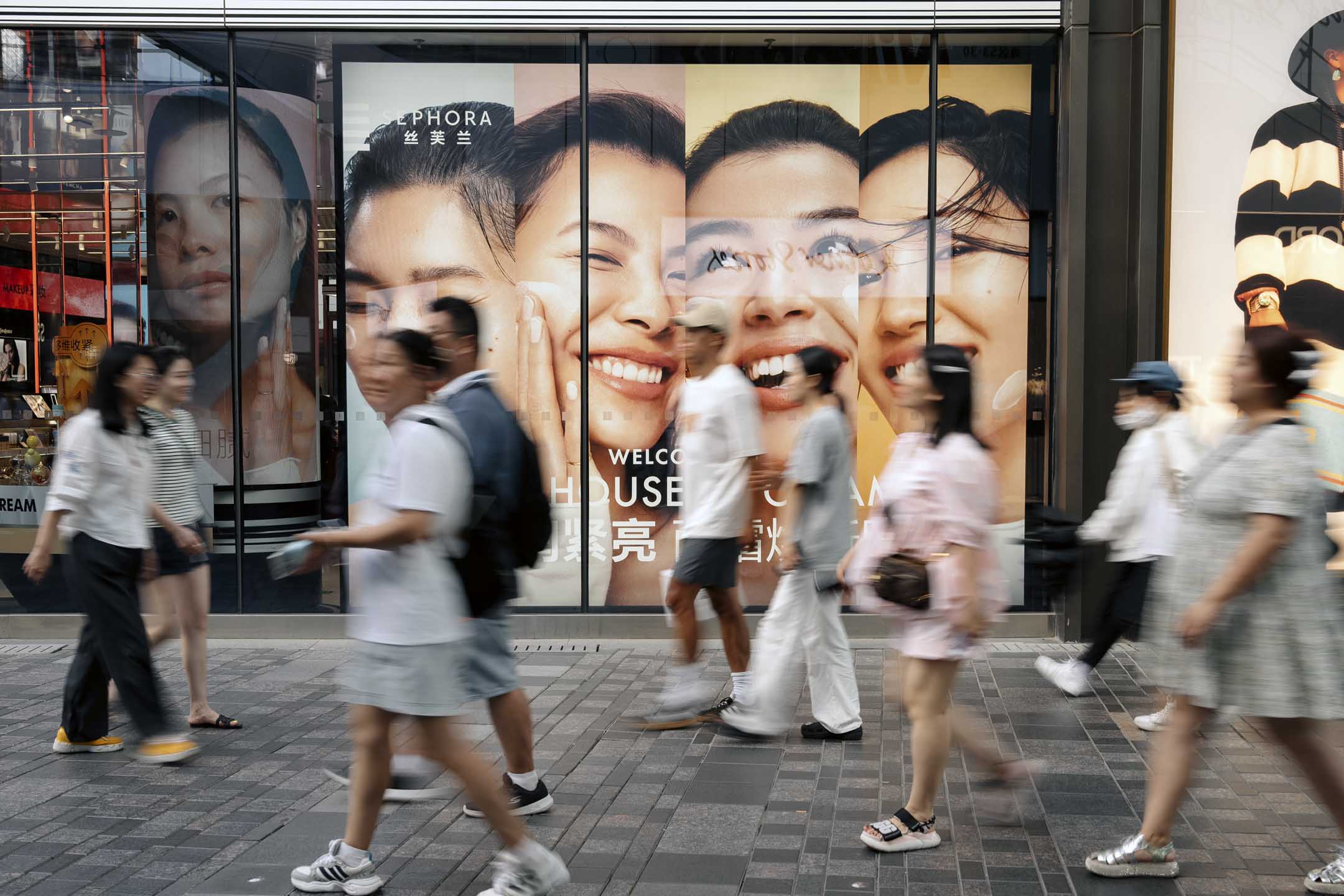 2024年8月22日，中國北京，行人經過 LVMH 集團經營的絲芙蘭(Sephora) 專賣店廣告。攝：Na Bian/Bloomberg via Getty Images