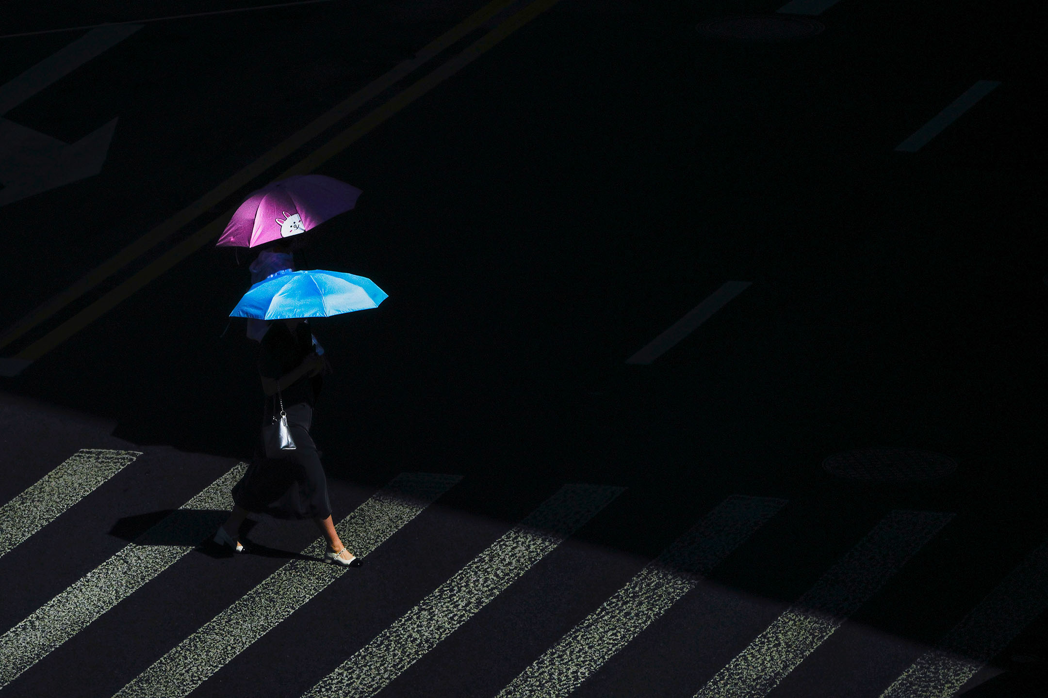 2024年7月4日，中國上海，行人撐著雨傘過馬路。攝：Andy Wong/AP/達志影像