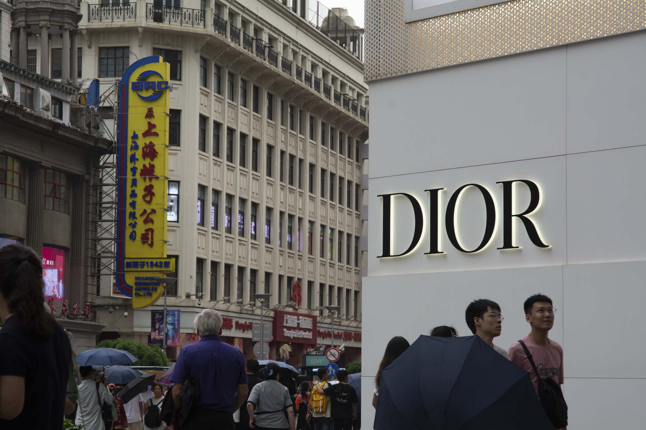 2024年6月22日，遊客走過中國上海南京東路中心購物區的 Dior 店。攝：Ying Tang/NurPhoto via Getty Images