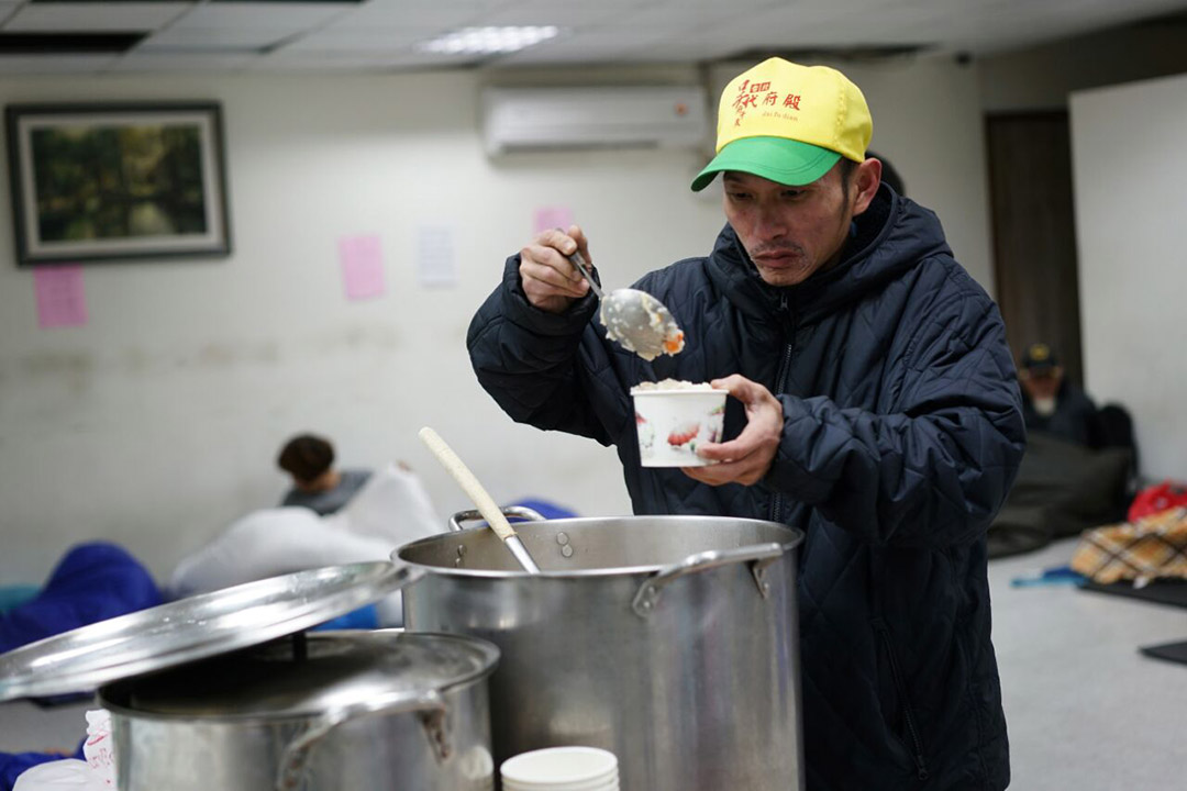 無家者在低溫下到台北市政府社會局萬華社會福利服務中心避寒及領取熱食。攝：張國耀/端傳媒