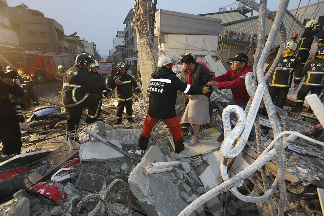 2016年2月6日，台南，救援人員協助一名傷者離開已倒塌的樓房。攝：AP Photo