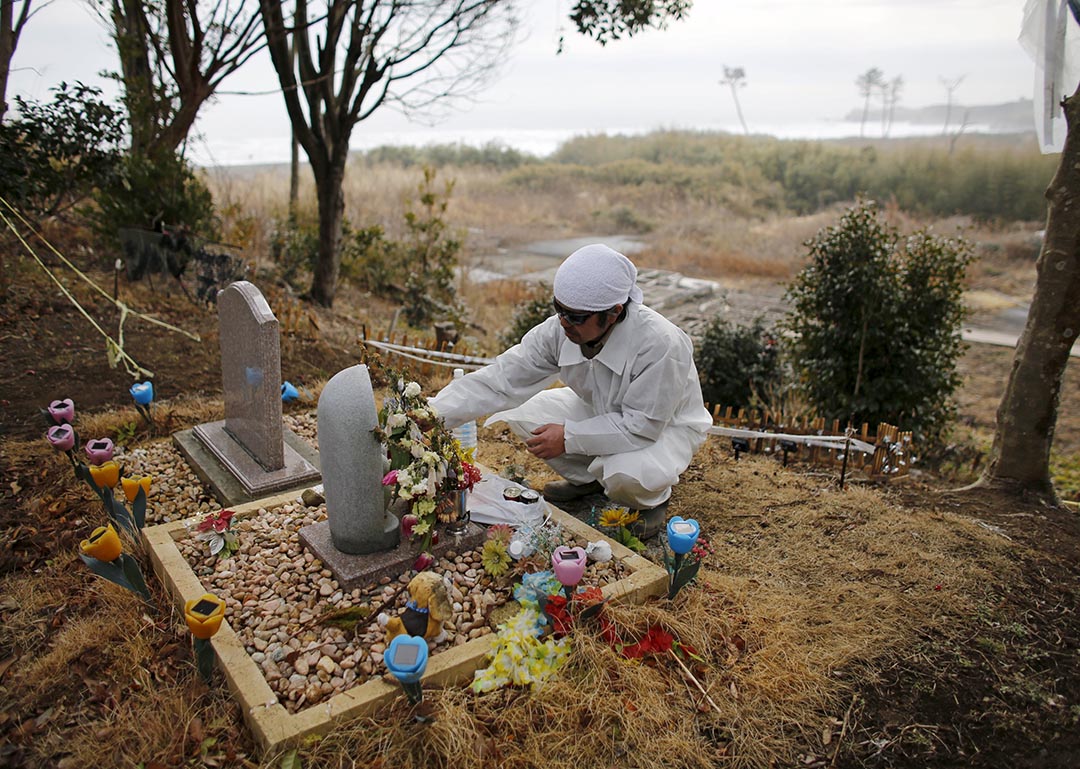 木村為家人的墓碑更換鮮花。