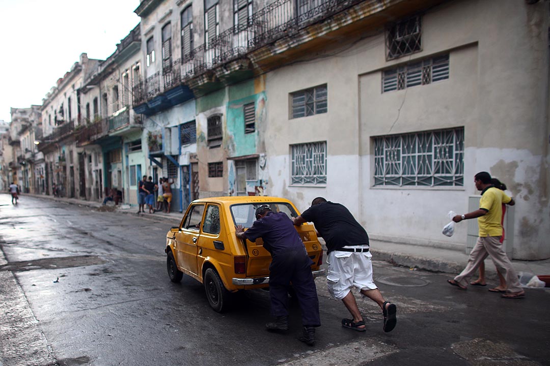 两名市民在街上推一辆古典车。摄 : Carl Court/GETTY